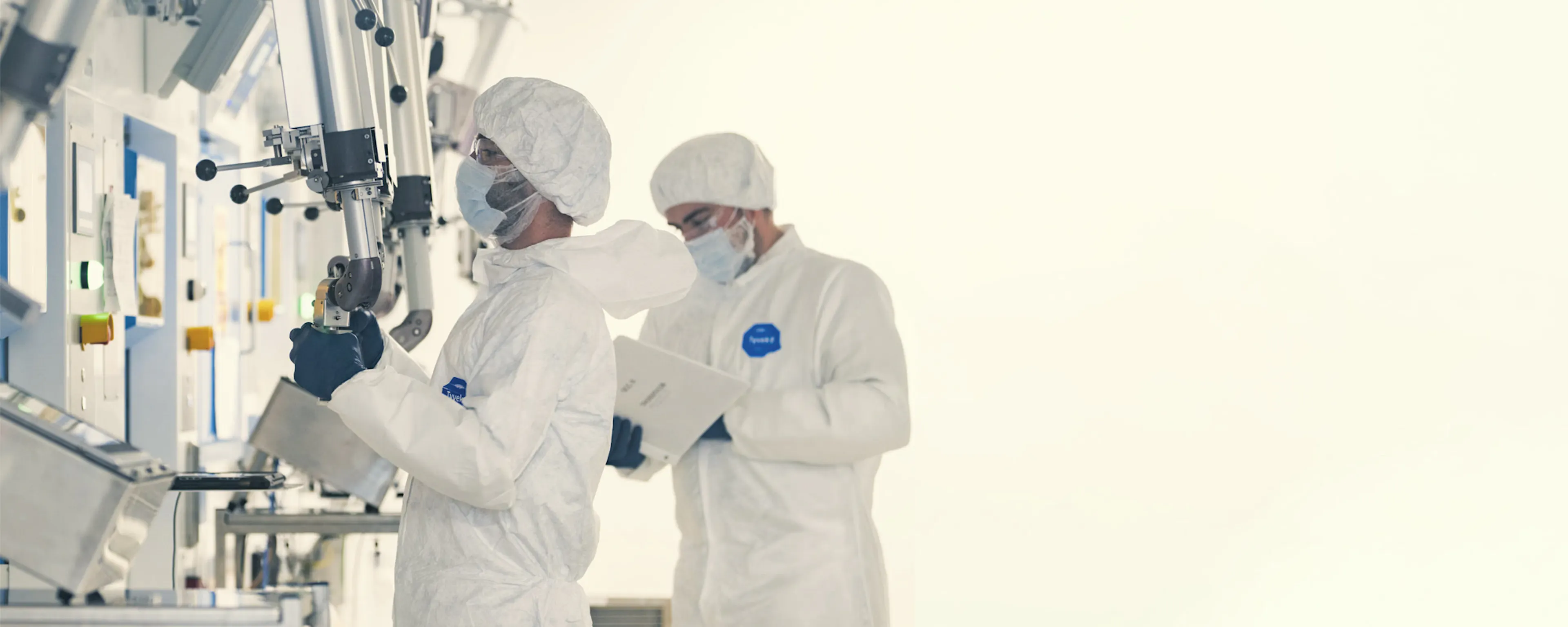 Technicians in cleanroom suits working in a sterile production area — SHINE Medical