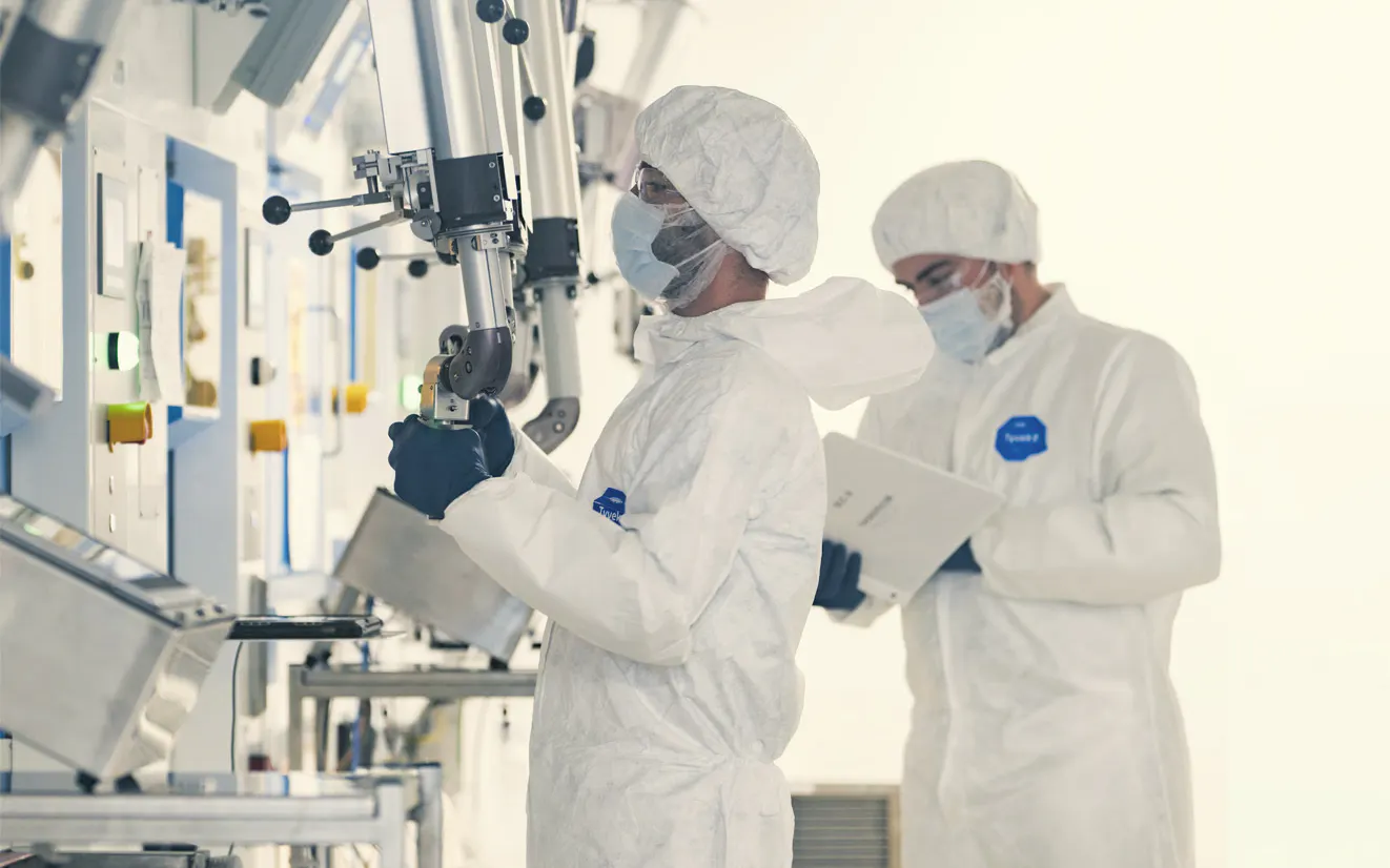 Technicians in cleanroom suits working in a sterile production area — SHINE Medical