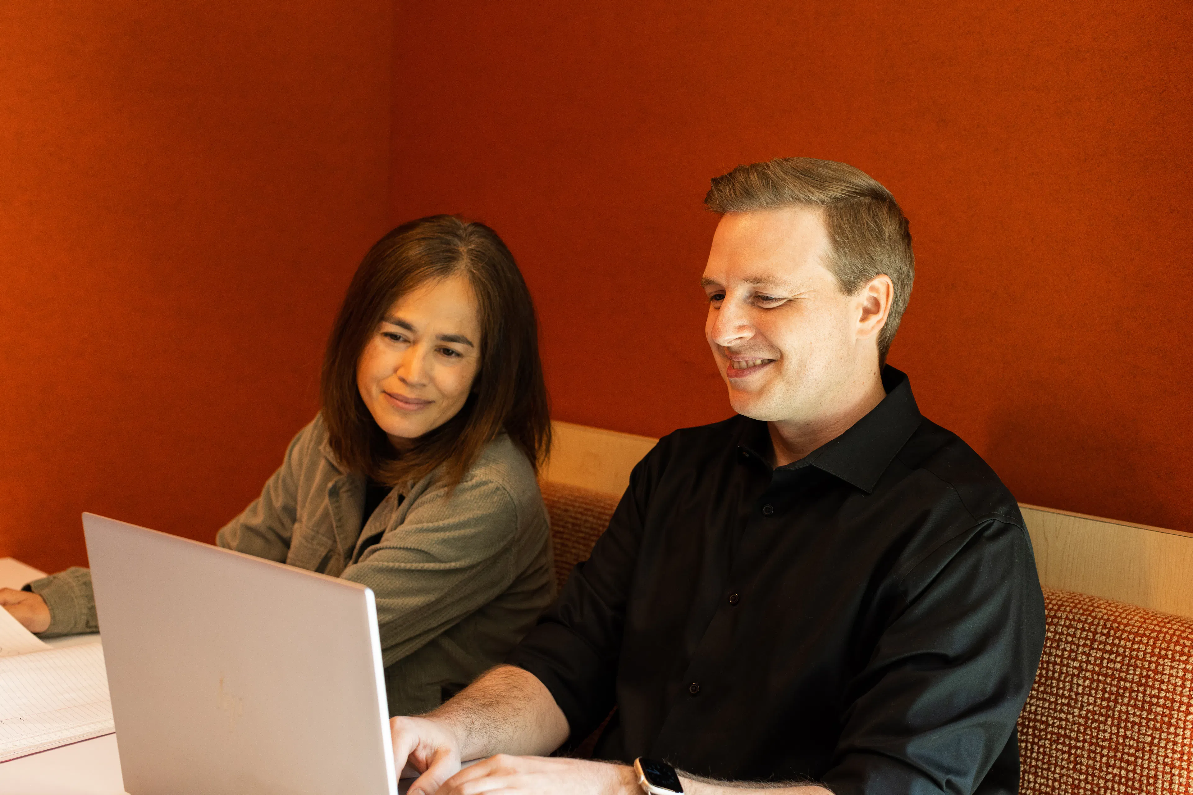 Two Luxent colleagues working together at a laptop