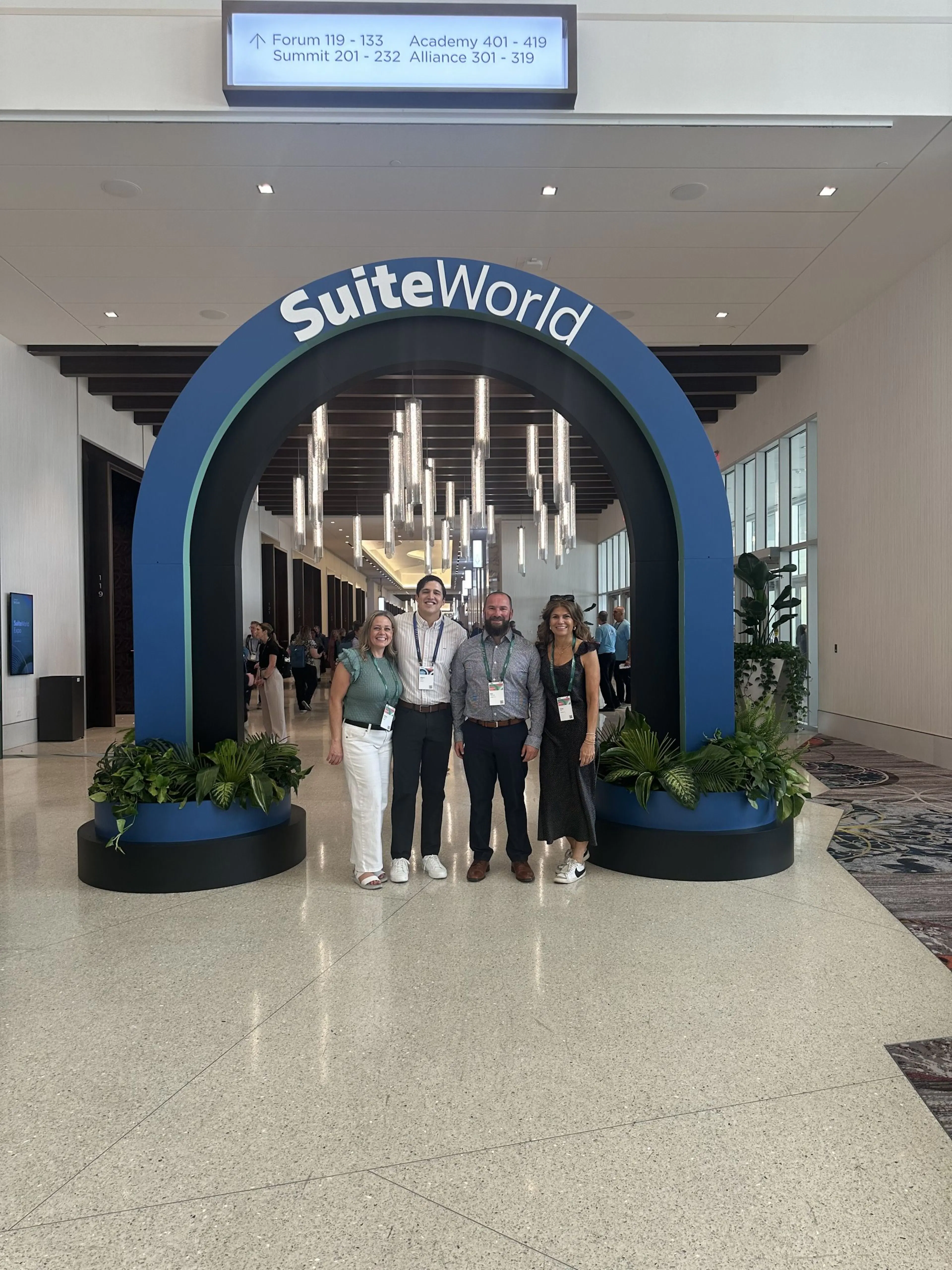 Luxent team members under the SuiteWorld entrance arch at the convention center