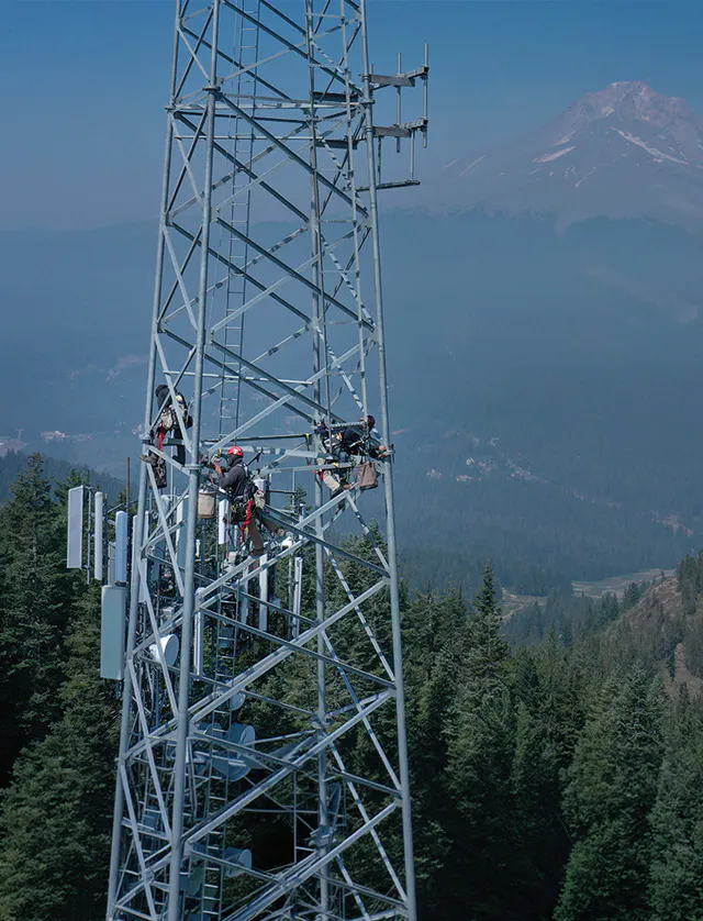 Technicians working atop a lattice communications tower — Day Wireless