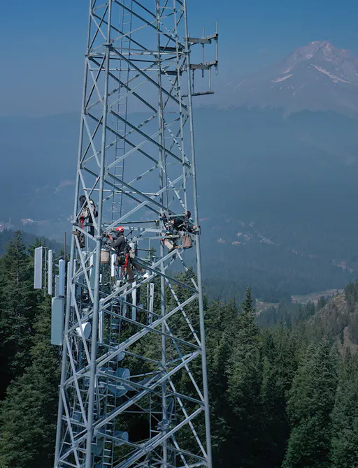 Technicians working atop a lattice communications tower — Day Wireless