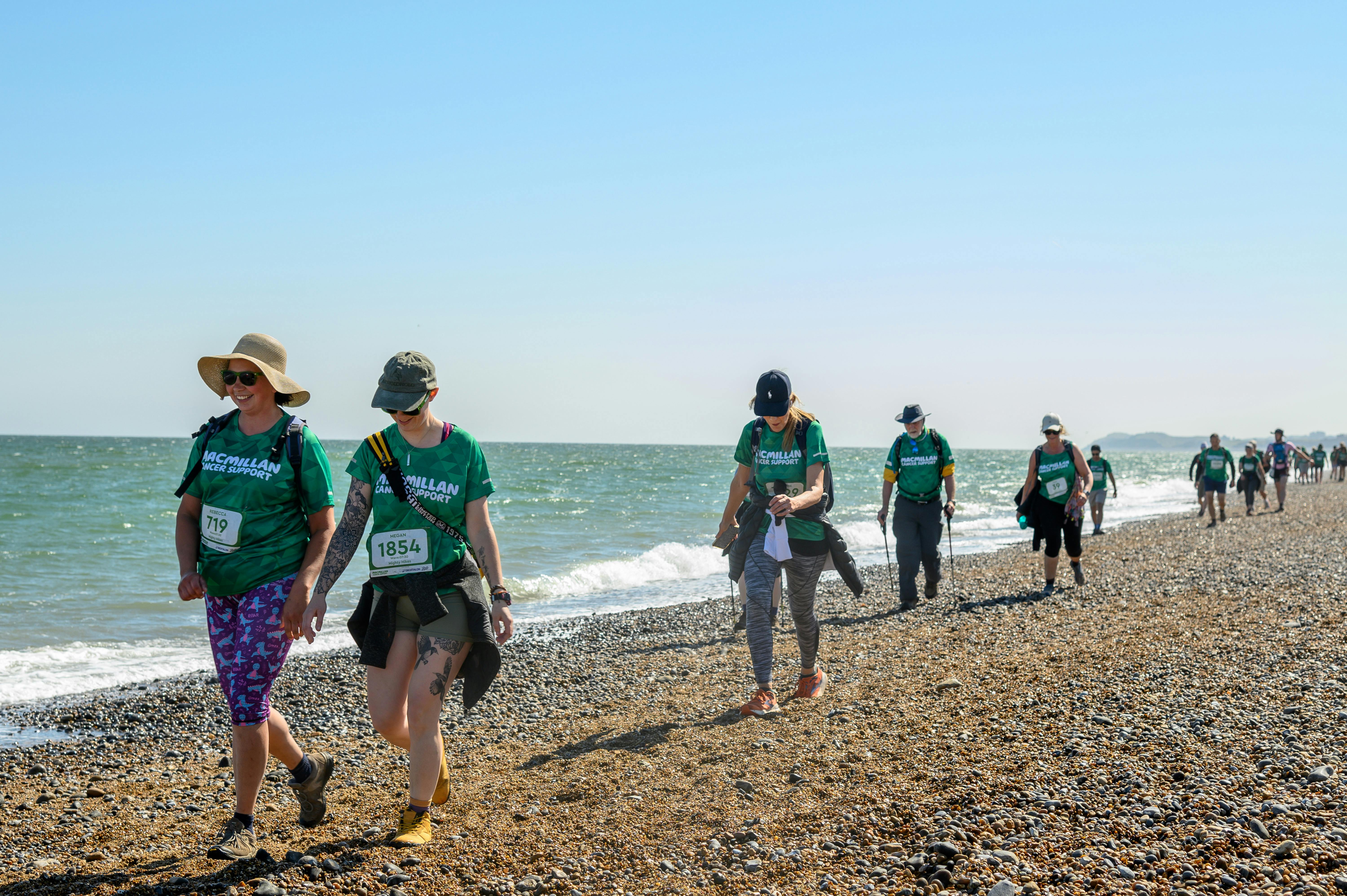 A group of hikers walking along the shingle beach
