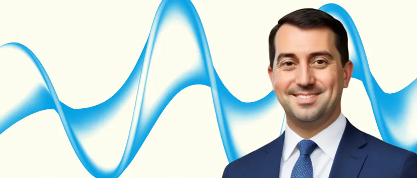 image of man with brown hair in a suit on a cream background with a blue wave