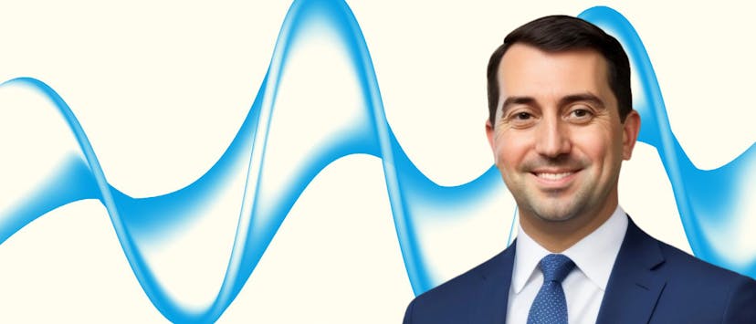image of man with brown hair in a suit on a cream background with a blue wave