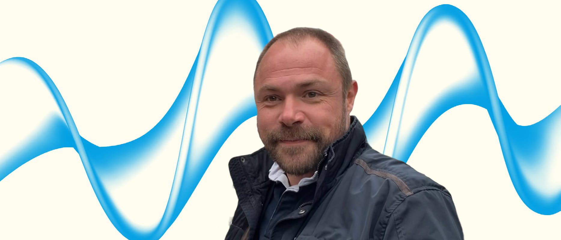 cream banner with blue wave and a man wearing a jacket with beard