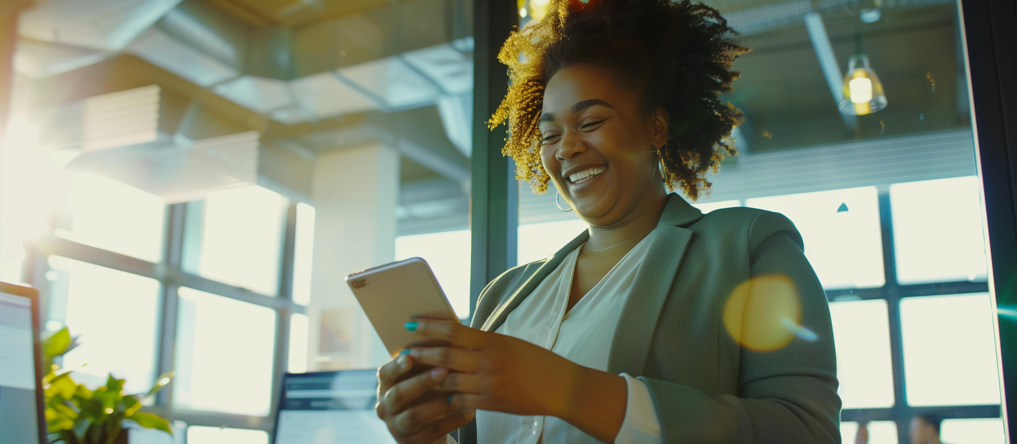 A woman in a professional office smiling and using her phone