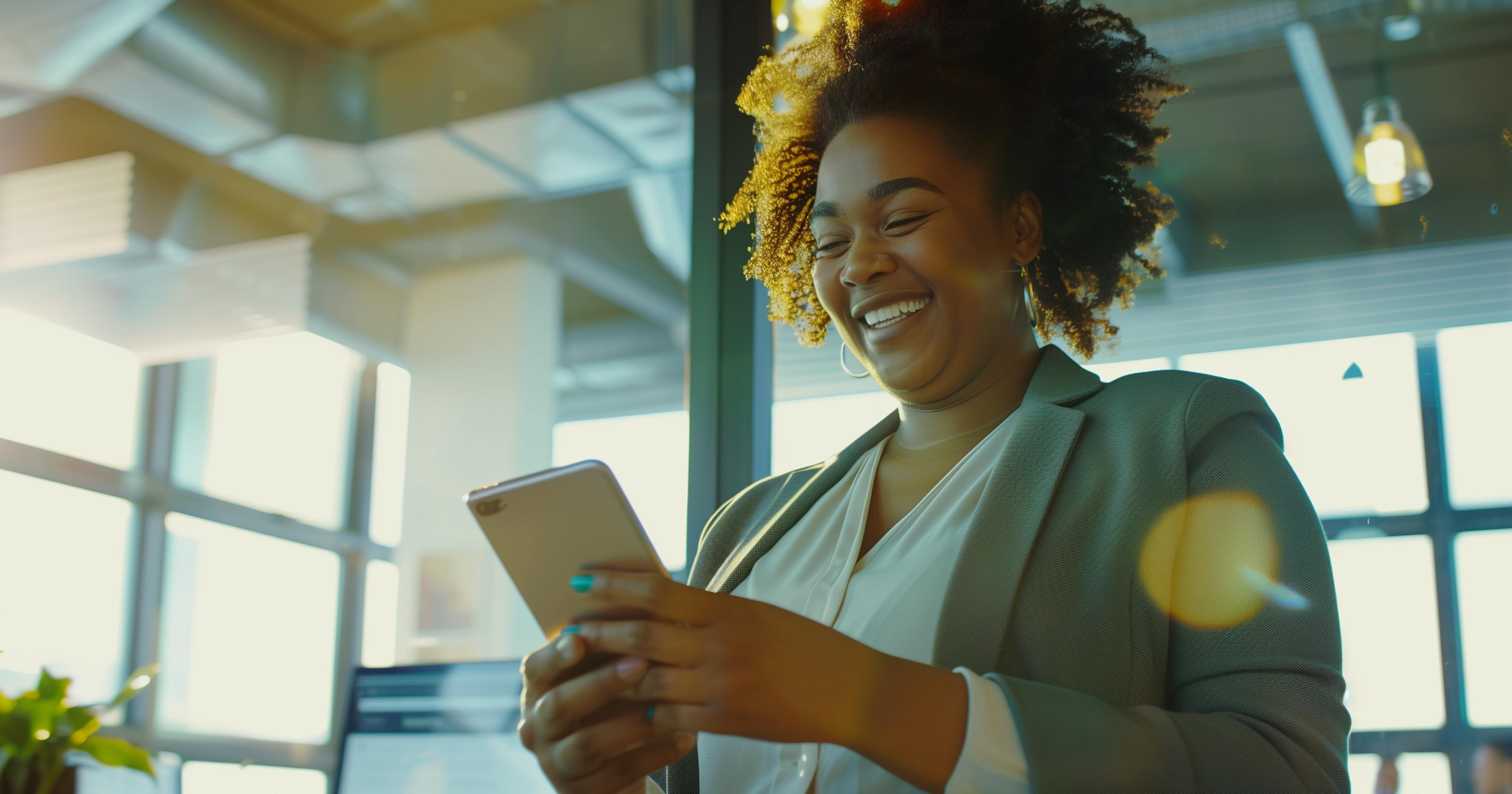 A woman in a professional office smiling and using her phone
