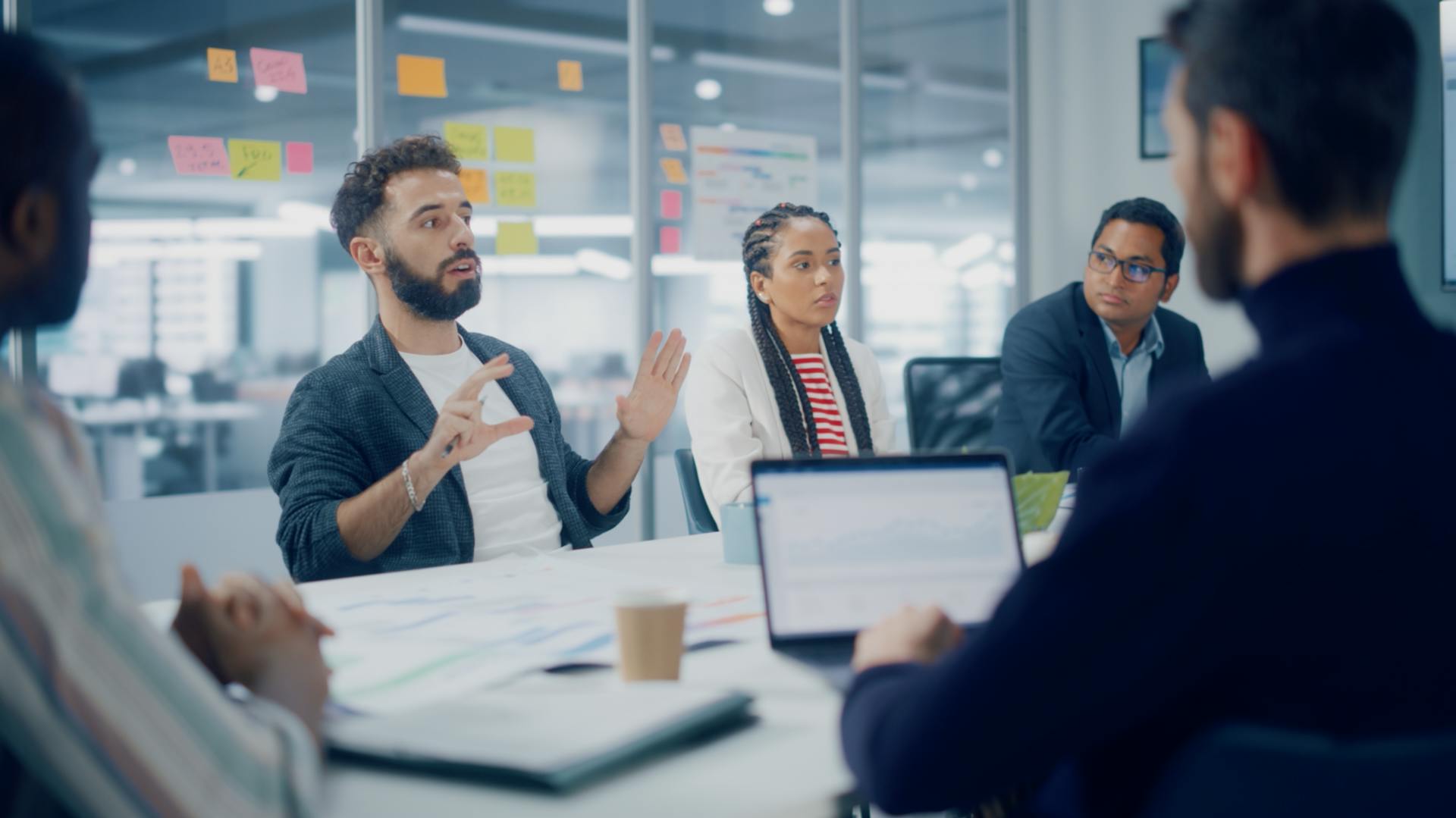 Group of coworkers working together in a modern office with glass walls.