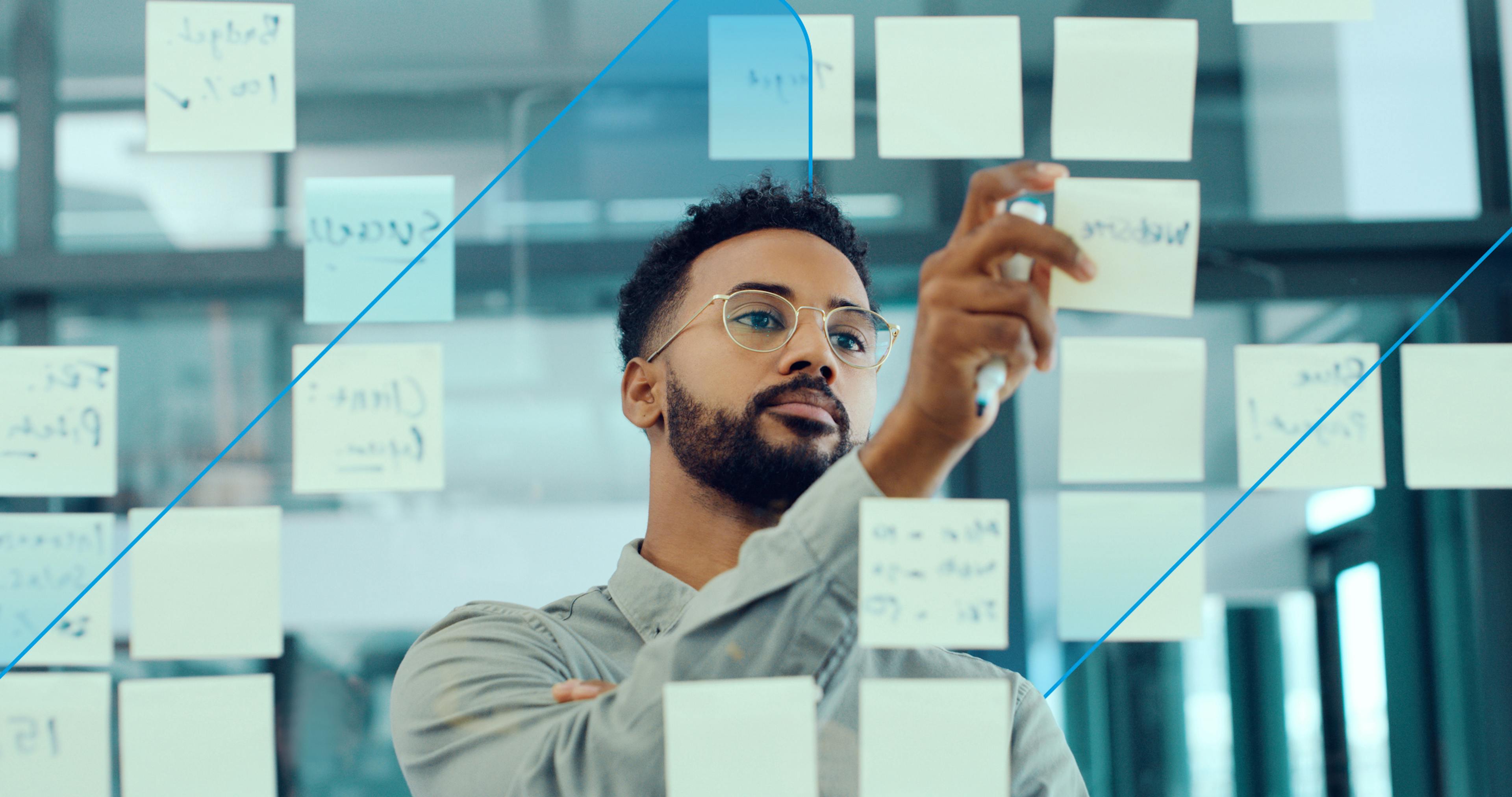 A man demonstrating agile thinking, brain storming with post-it notes