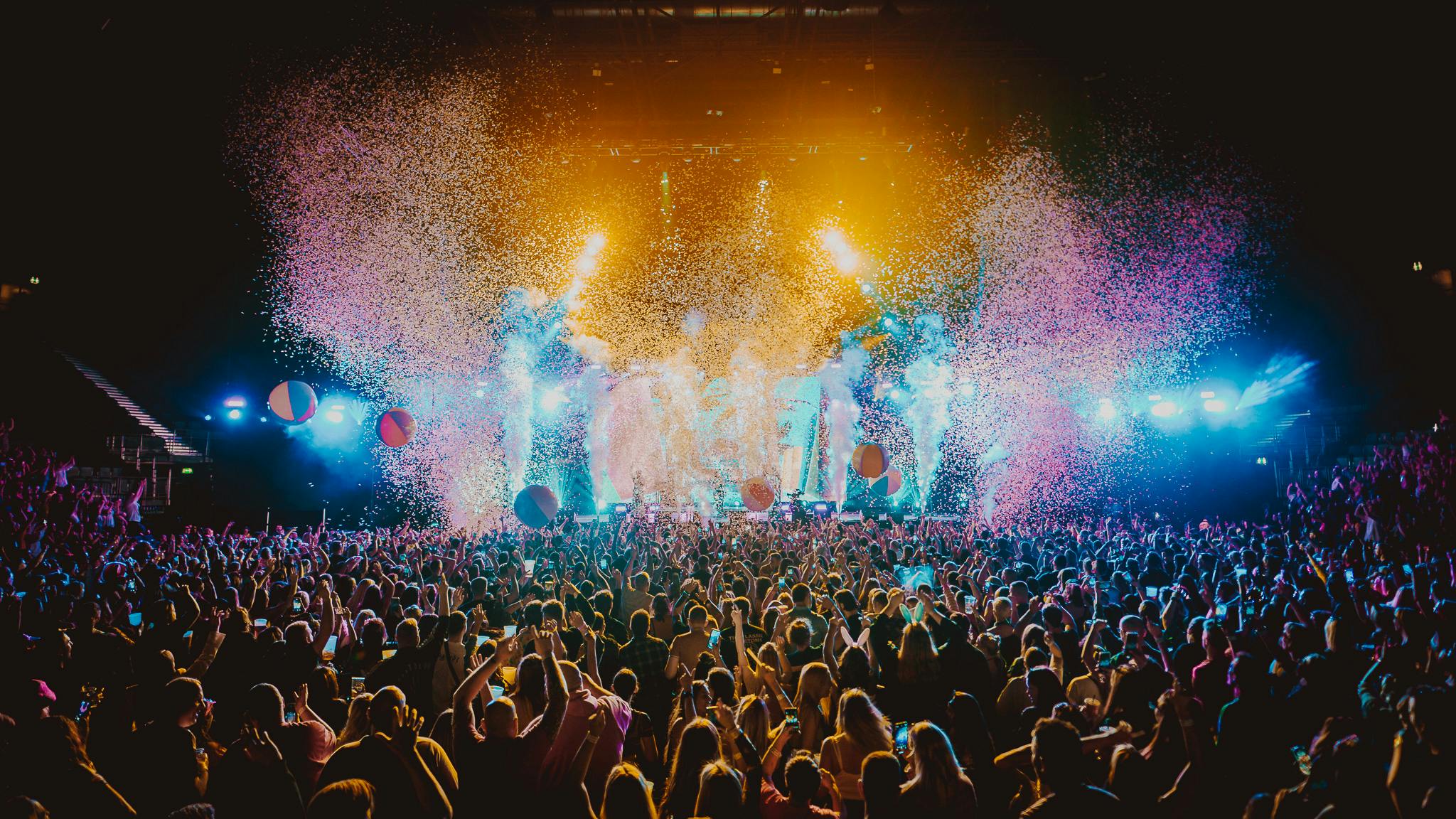 image of a crowd at an inside gig with confetti and lights