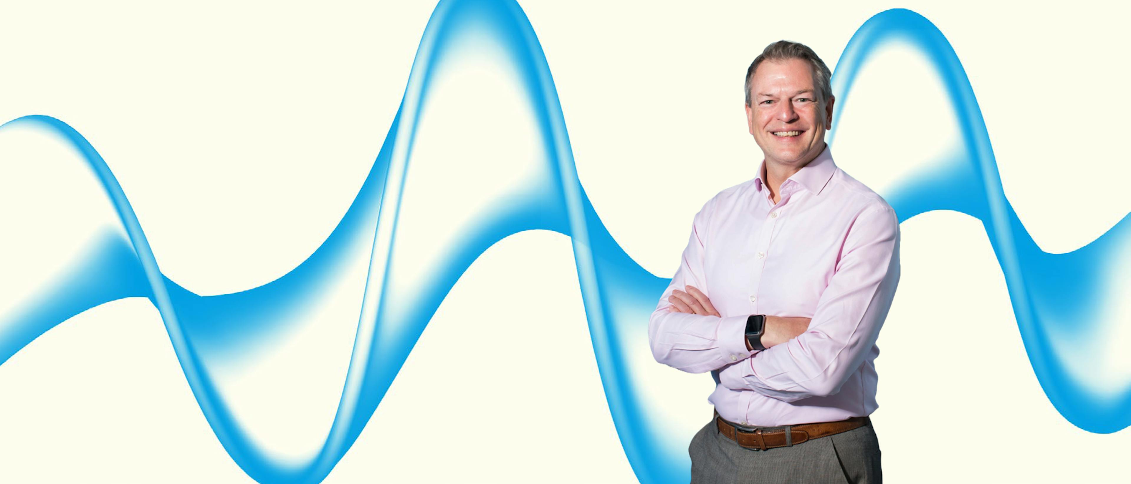 Image of a man on a cream background with a blue wave