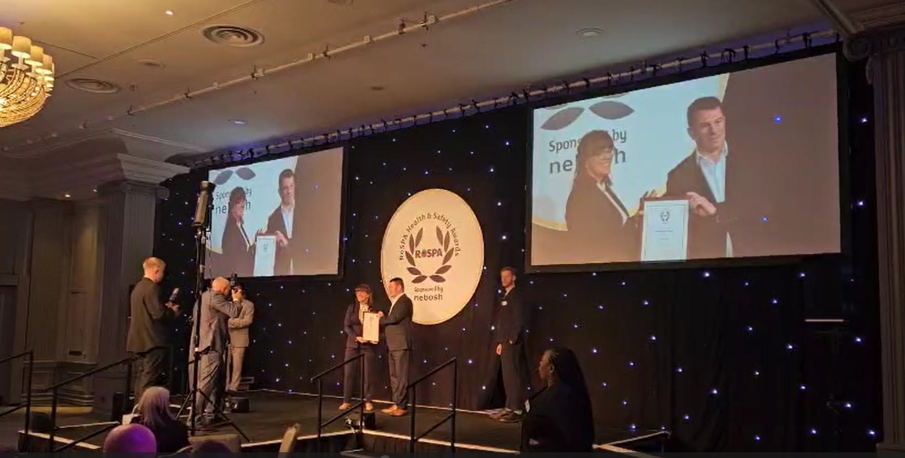 image of Macro rep accepting award on a stage