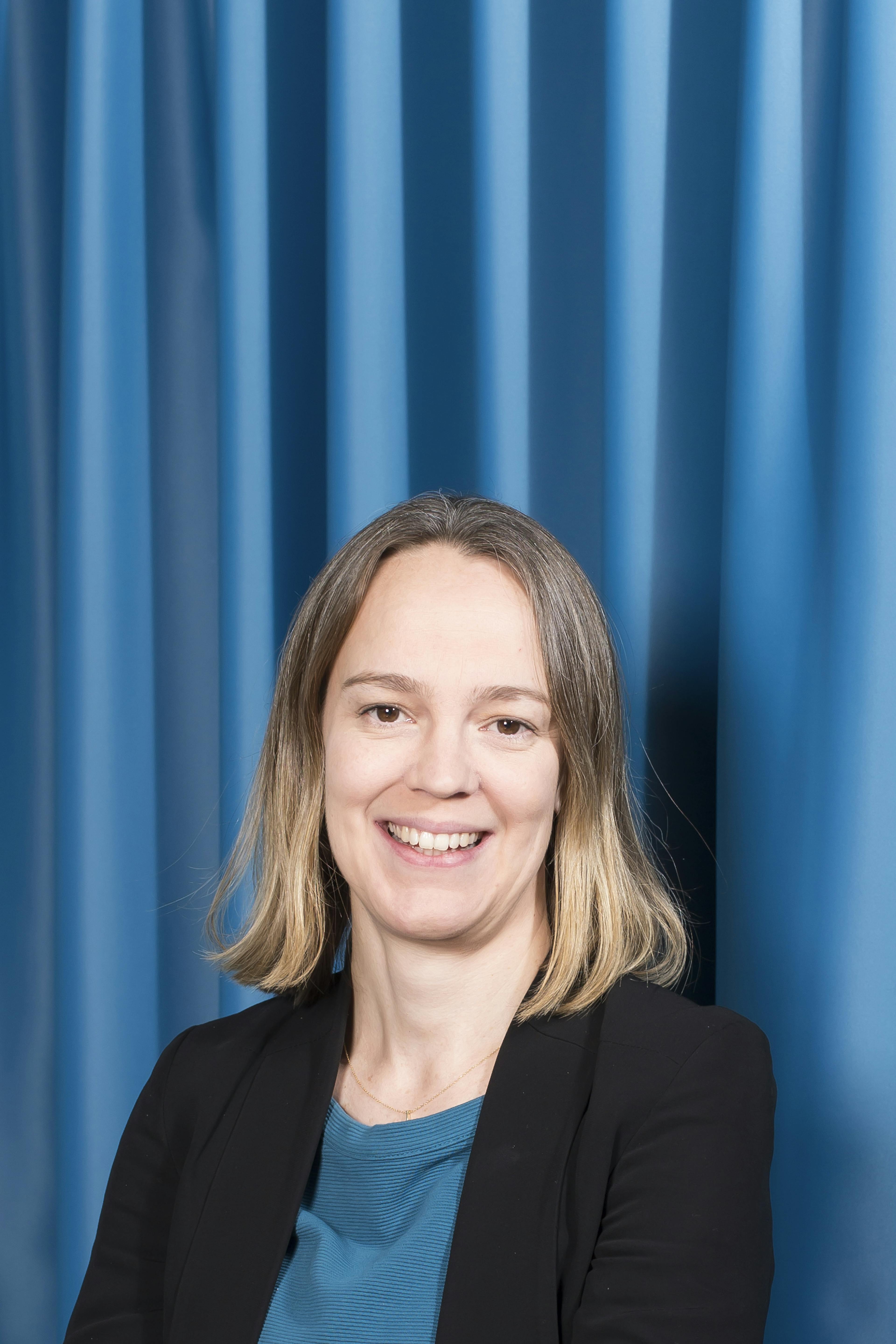 woman with blond hair on a blue background in a blue dress 