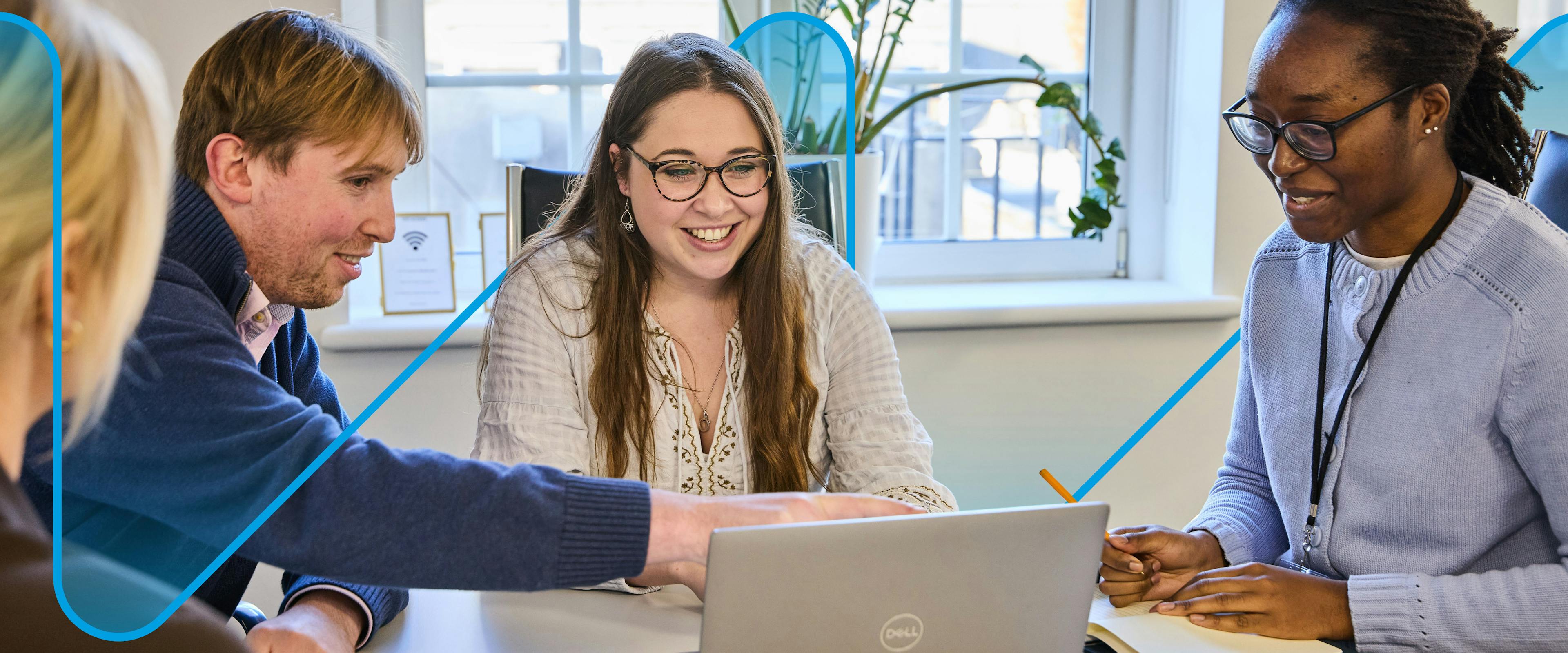 image of men and women looking at a laptop