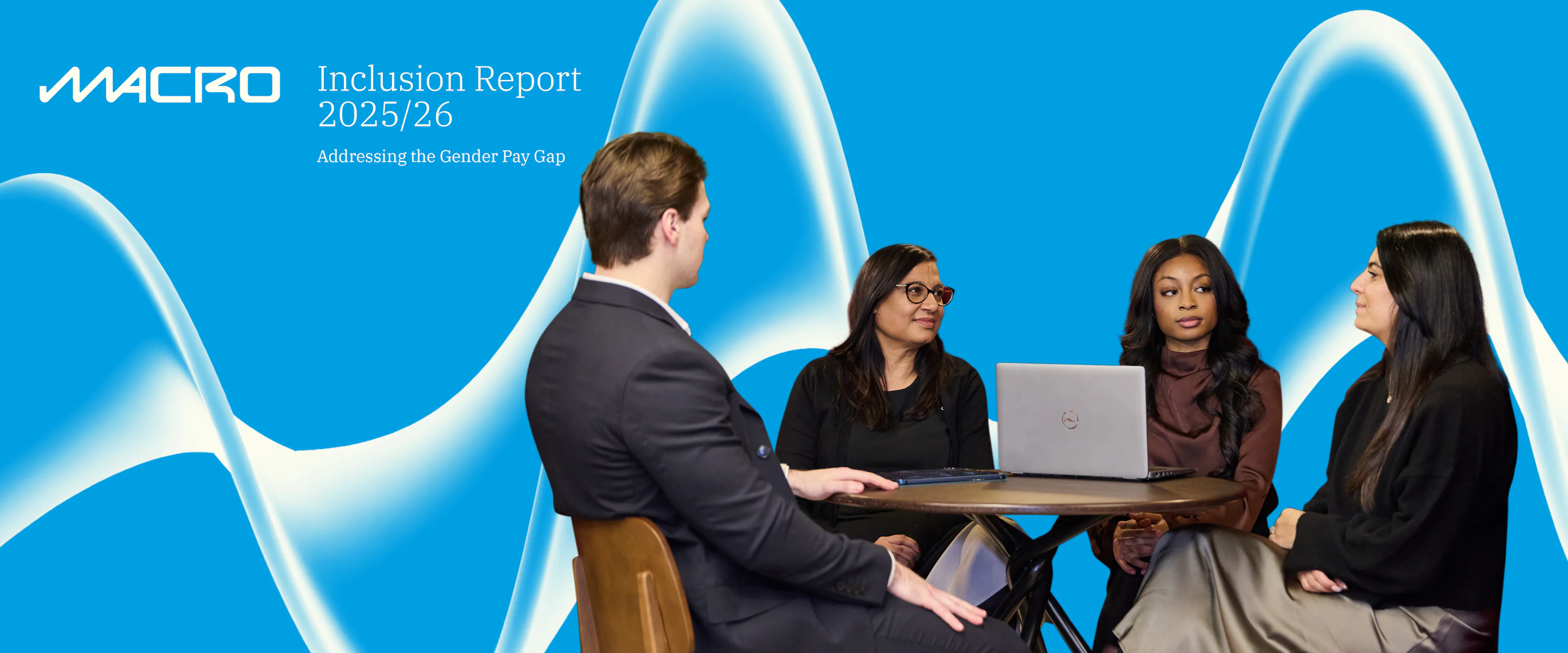 image of three women and one man sitting around a laptop