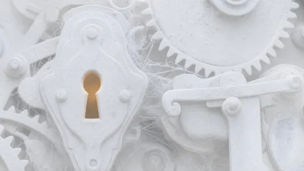 Macro di un vecchio meccanismo di serratura coperto di polvere e ragnatele, tutto in bianco opaco, con un tenue bagliore ambra dentro il buco della serratura