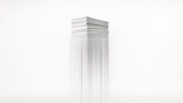Pila di documenti di carta su fondo bianco: la parte alta è nitida, la metà bassa si dissolve in scie verticali di luce