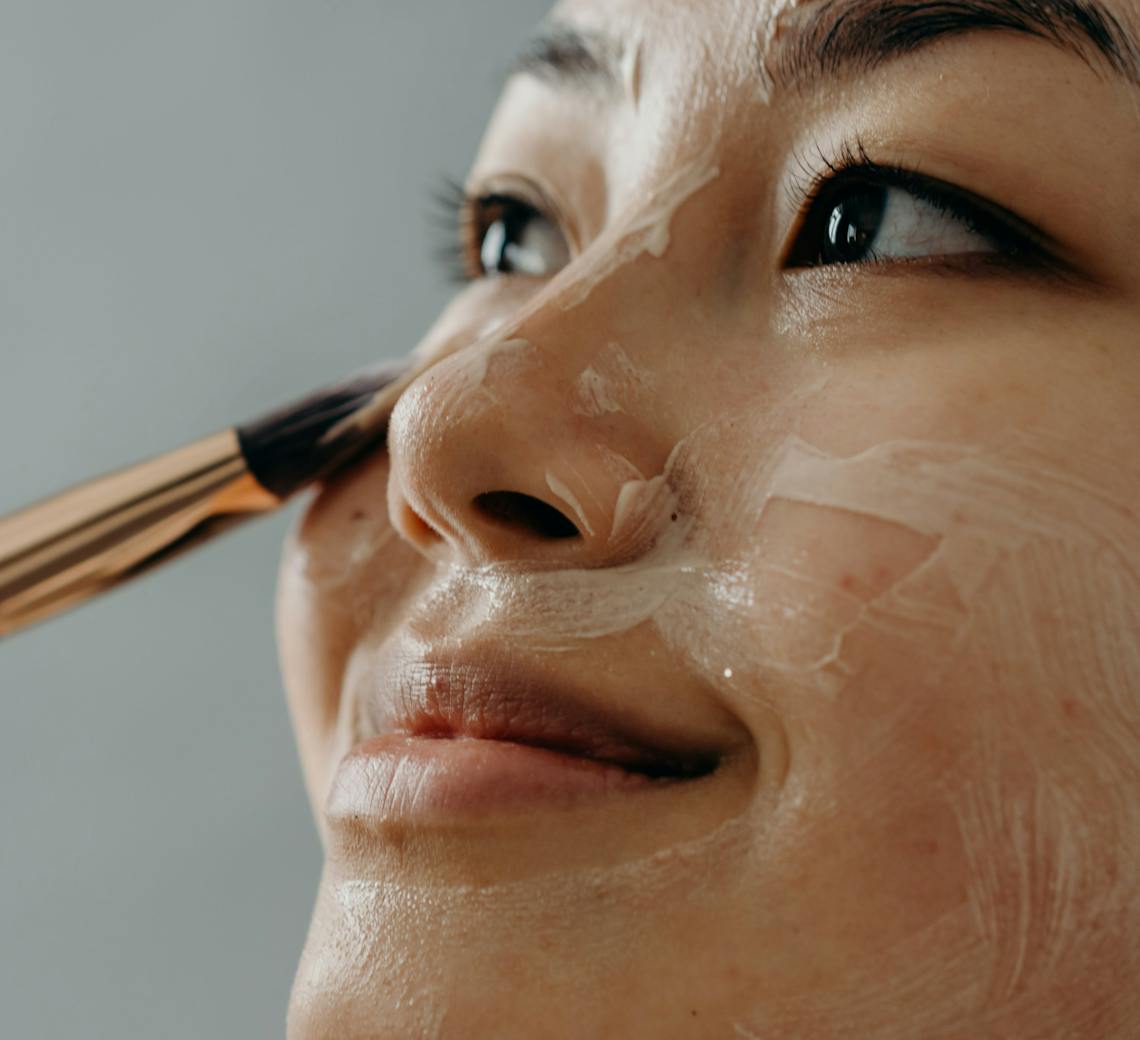 Une femme qui s'applique un soin sur la peau du visage