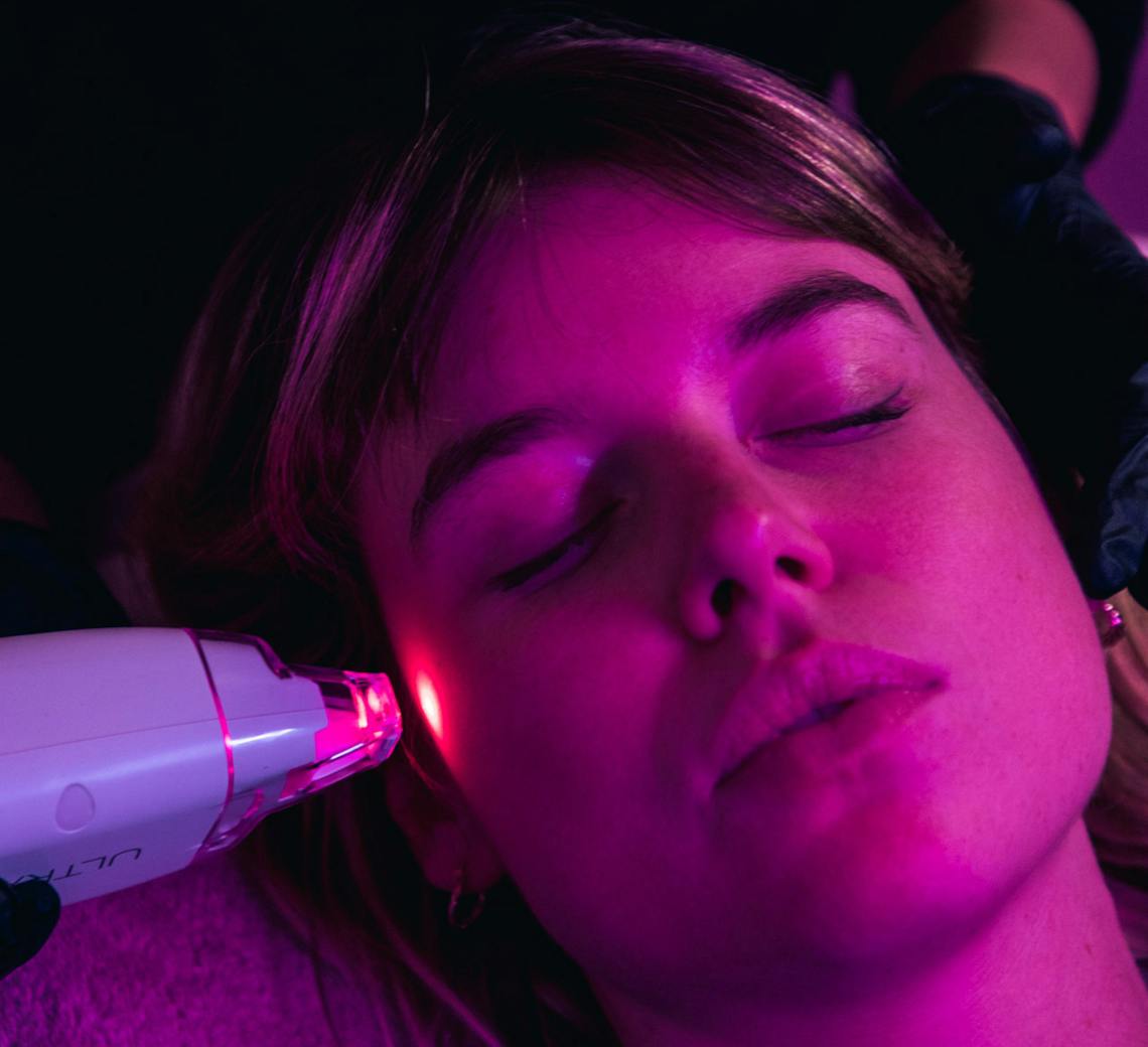 Visage de femme sous une lumière LED.