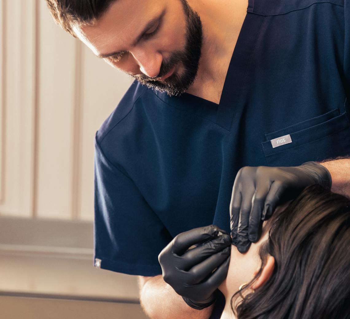 Chirurgien spécialiste qui réalise des injections dans le visage d'une patiente chez Maison Yokō.