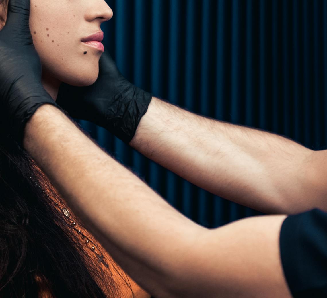 Jeune femme en consultation avec un médecin qui analyse son visage.