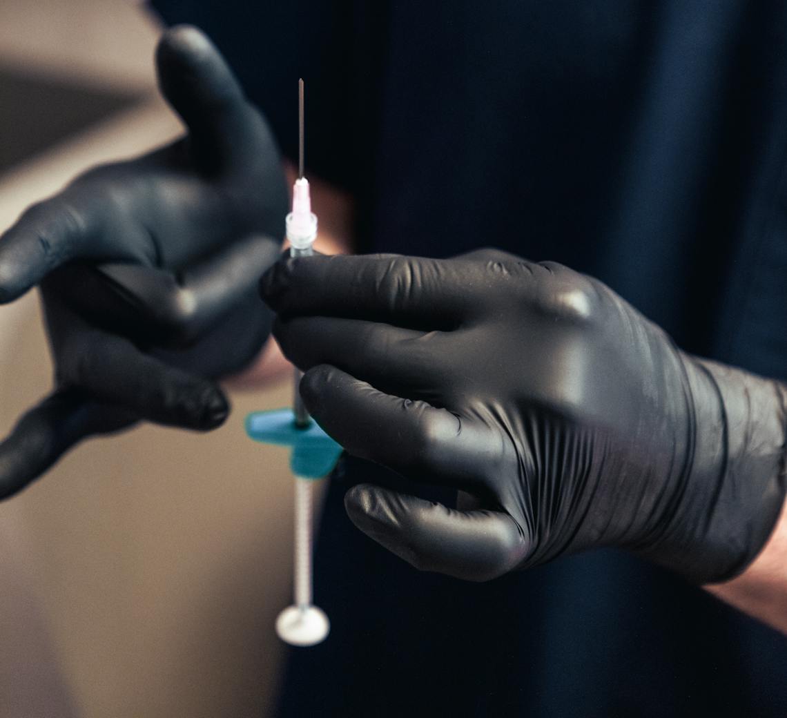 Praticien expert avec seringue pour injections.