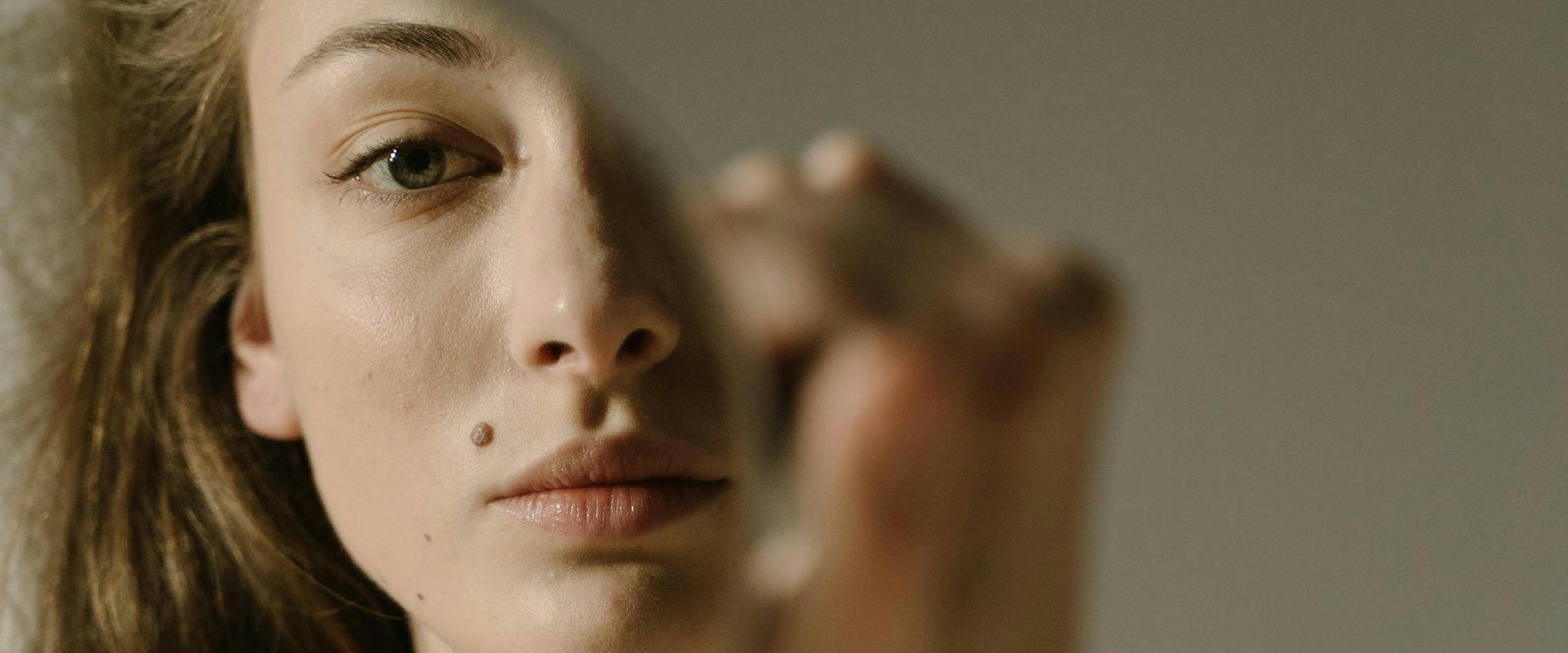 Jeune femme se regarde dans le miroir.