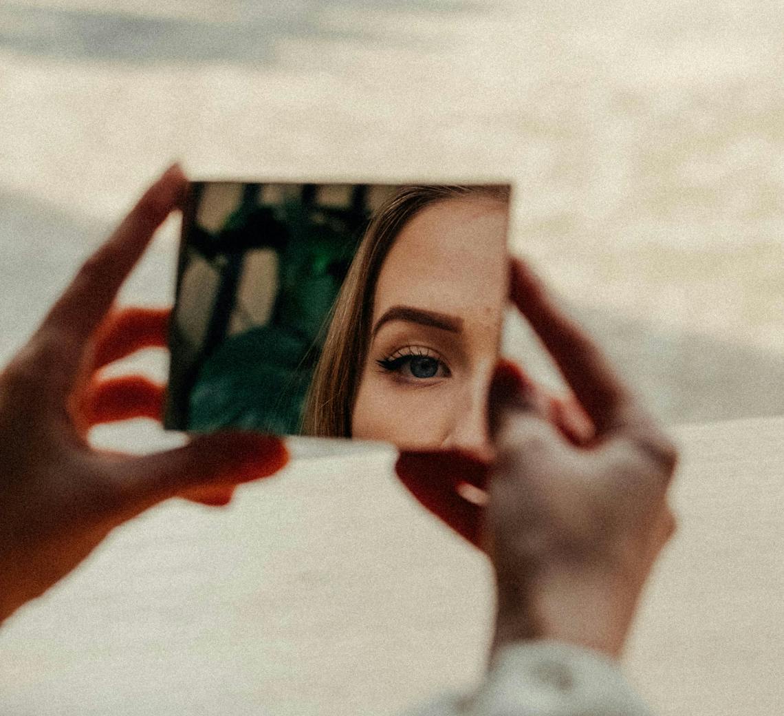 Jeune femme se regarde dans le miroir