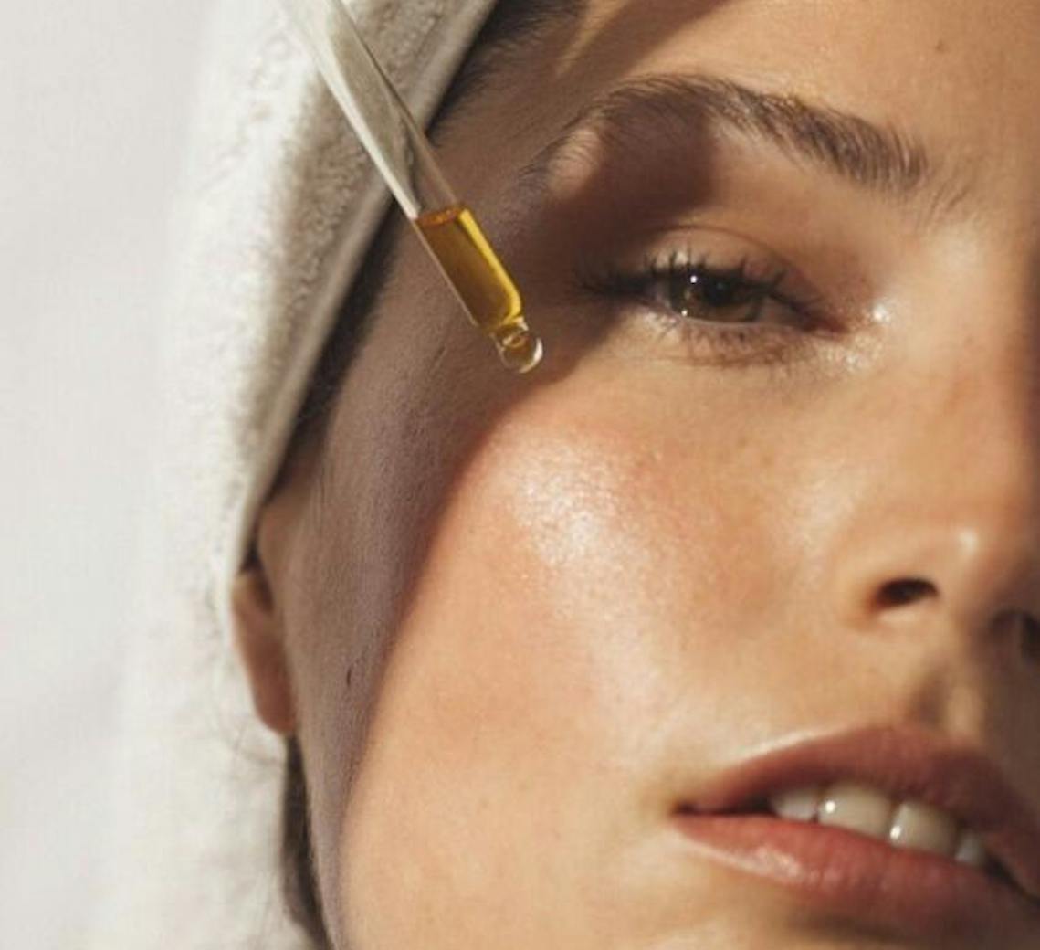 Jeune femme qui applique un sérum hydratant après un Hydrafacial à Lyon pour prolonger les bienfaits du soin.