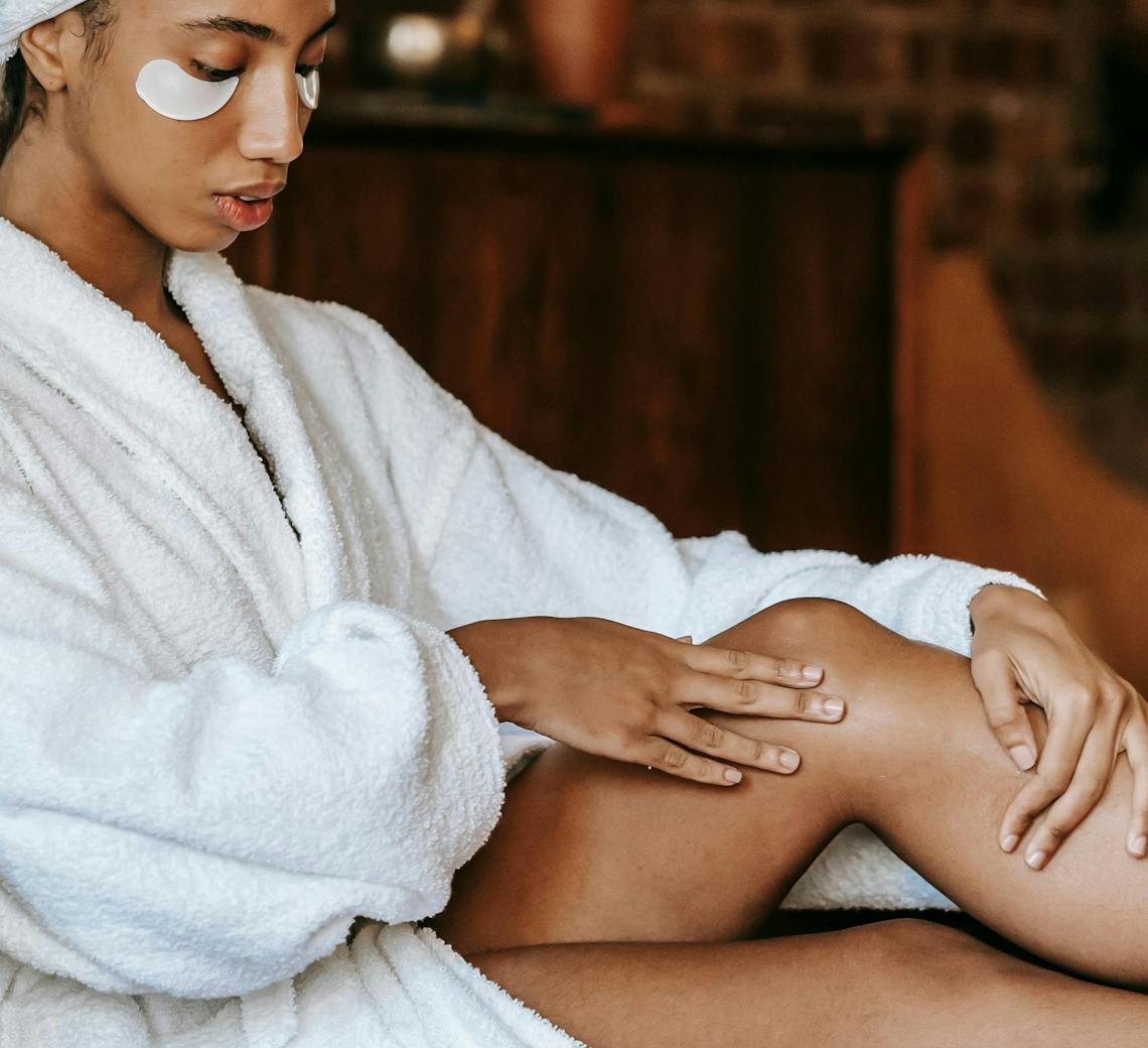 Jeune femme en peignoire avec un focus sur les jambes.