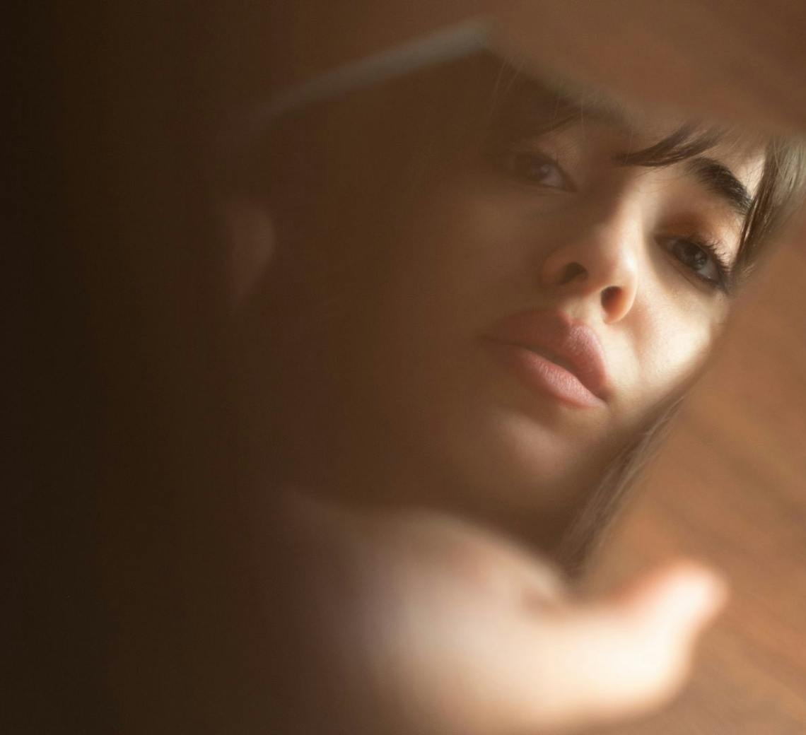 Jeune femme qui se regarde dans le miroir