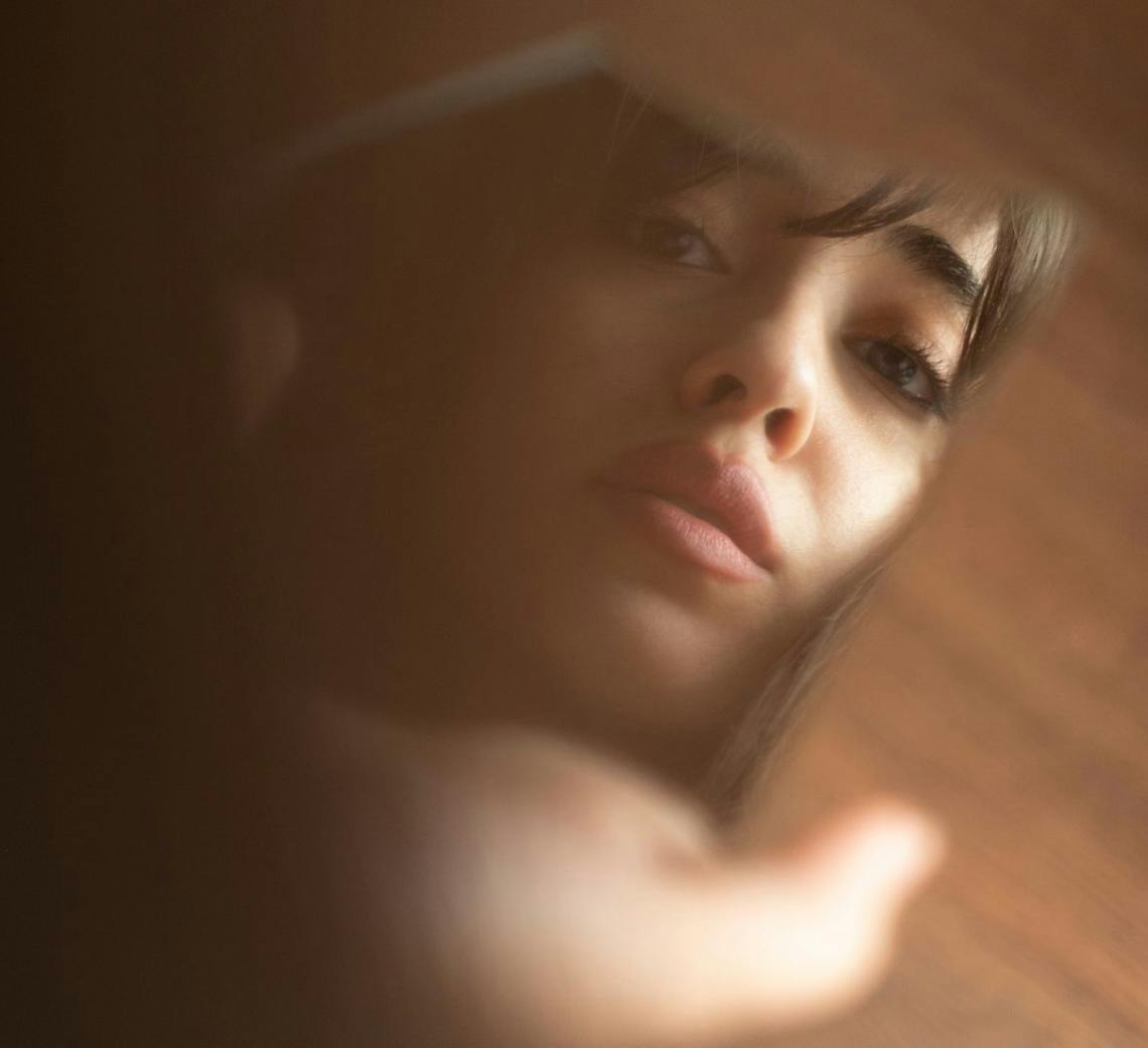 Jeune femme qui se regarde dans le miroir