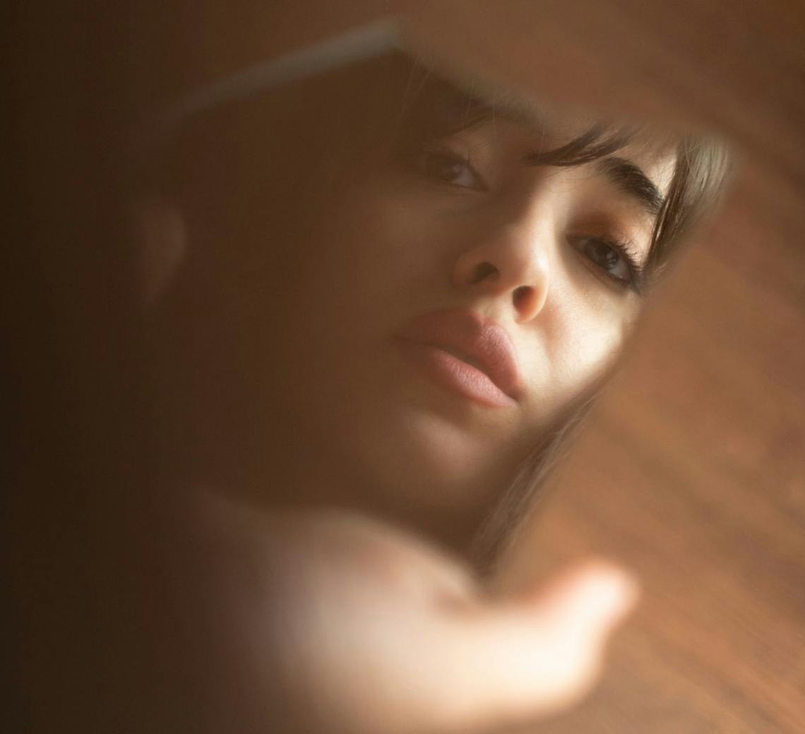 Jeune femme qui se regarde dans le miroir