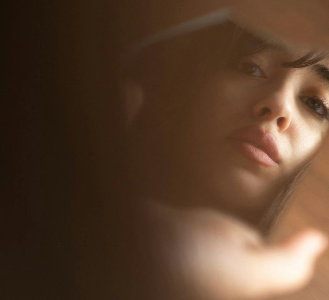 Jeune femme qui se regarde dans le miroir