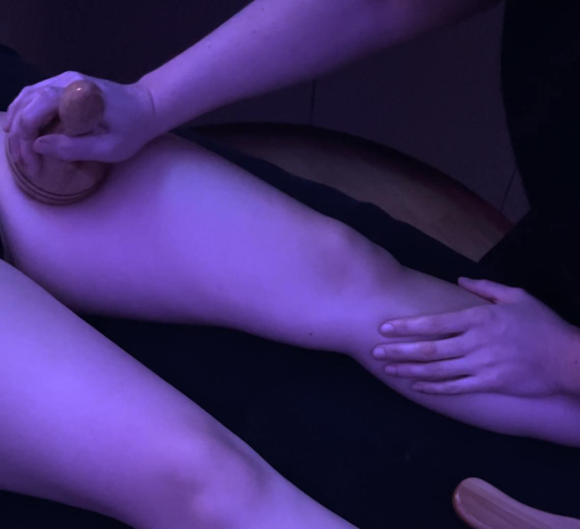 Experte qui réalise un drainage Renata França sur une patiente pour travailler sur sa cellulite sur la zone des cuisses.