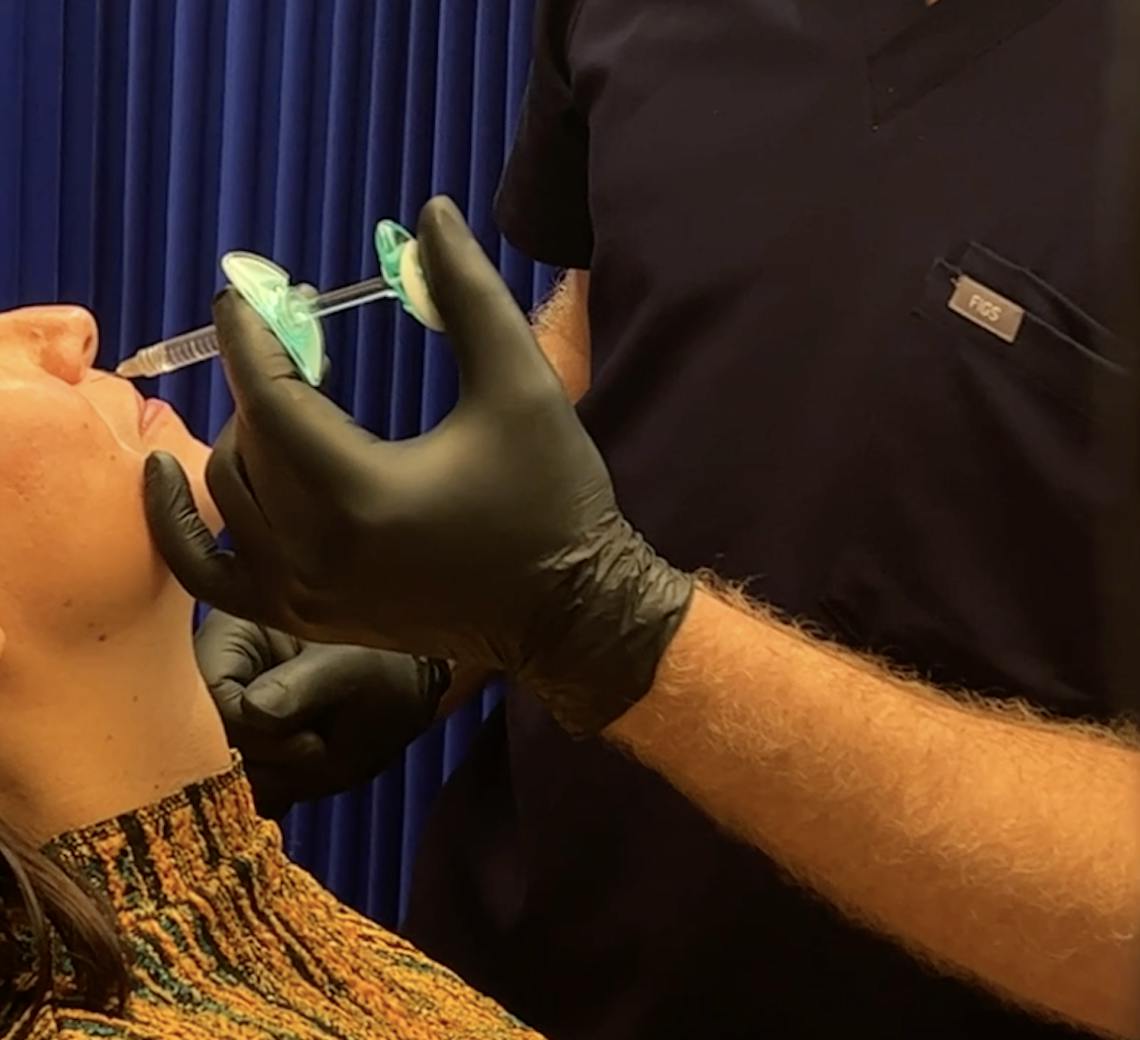 Femme qui se fait injecter de la toxine botulique dans le visage par un médecin à Lyon.