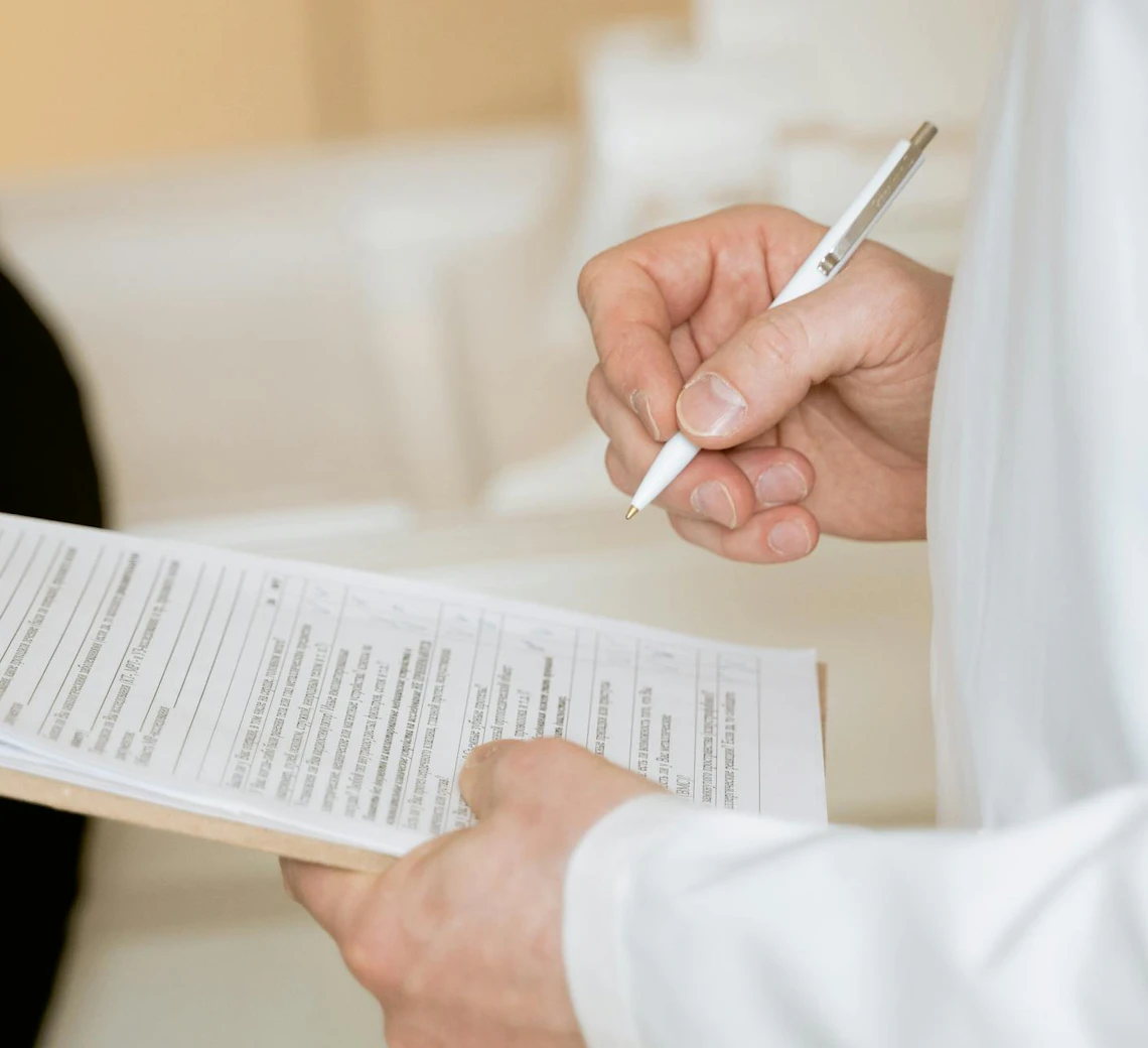 Professionnel de santé prenant des notes sur un document médical