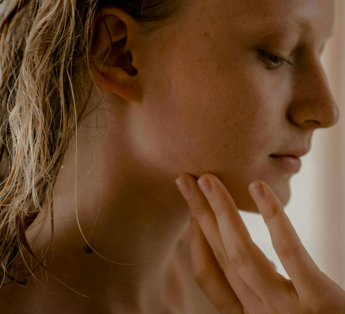 Femme qui se touche le visage.