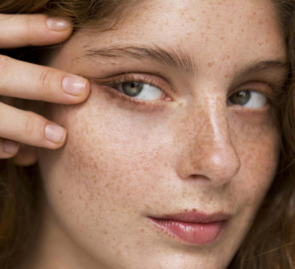 Portrait de jeune femme qui tire son oeil vers l'extérieur