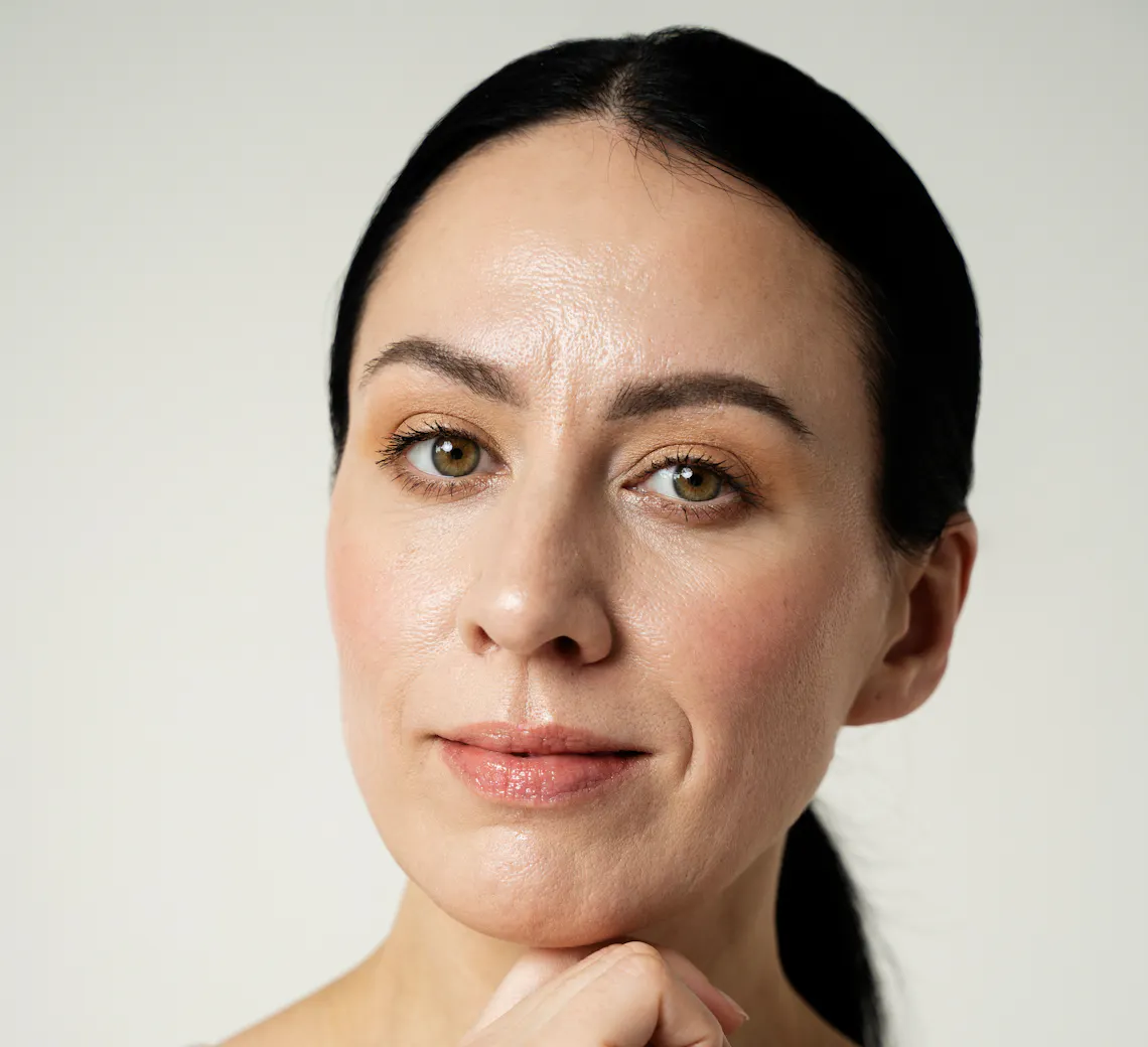 Portrait d’une femme brune, avec une texture de peau visible.