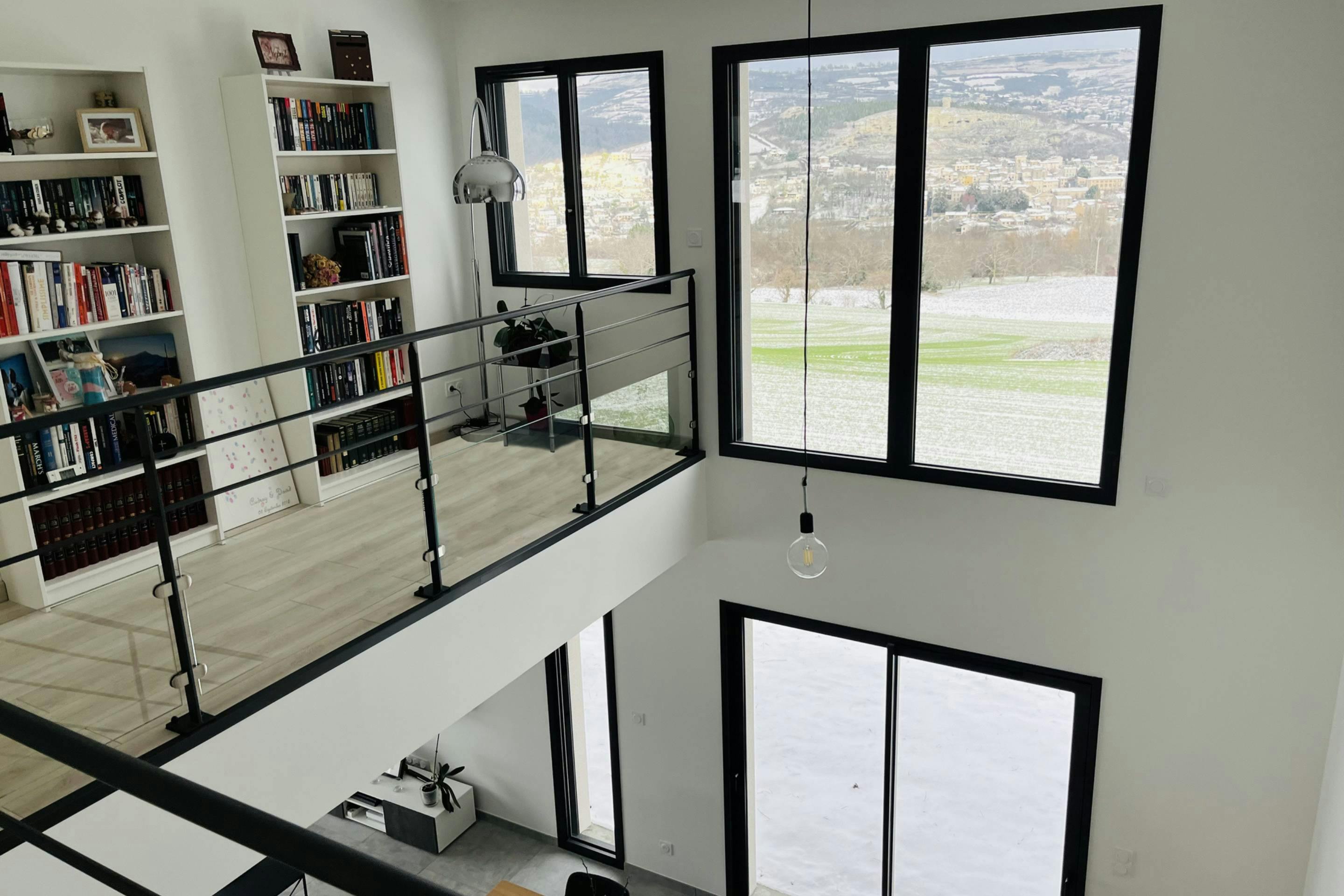 Bibliothèque sur mezzanine avec vue sur les monts d'Auvergne