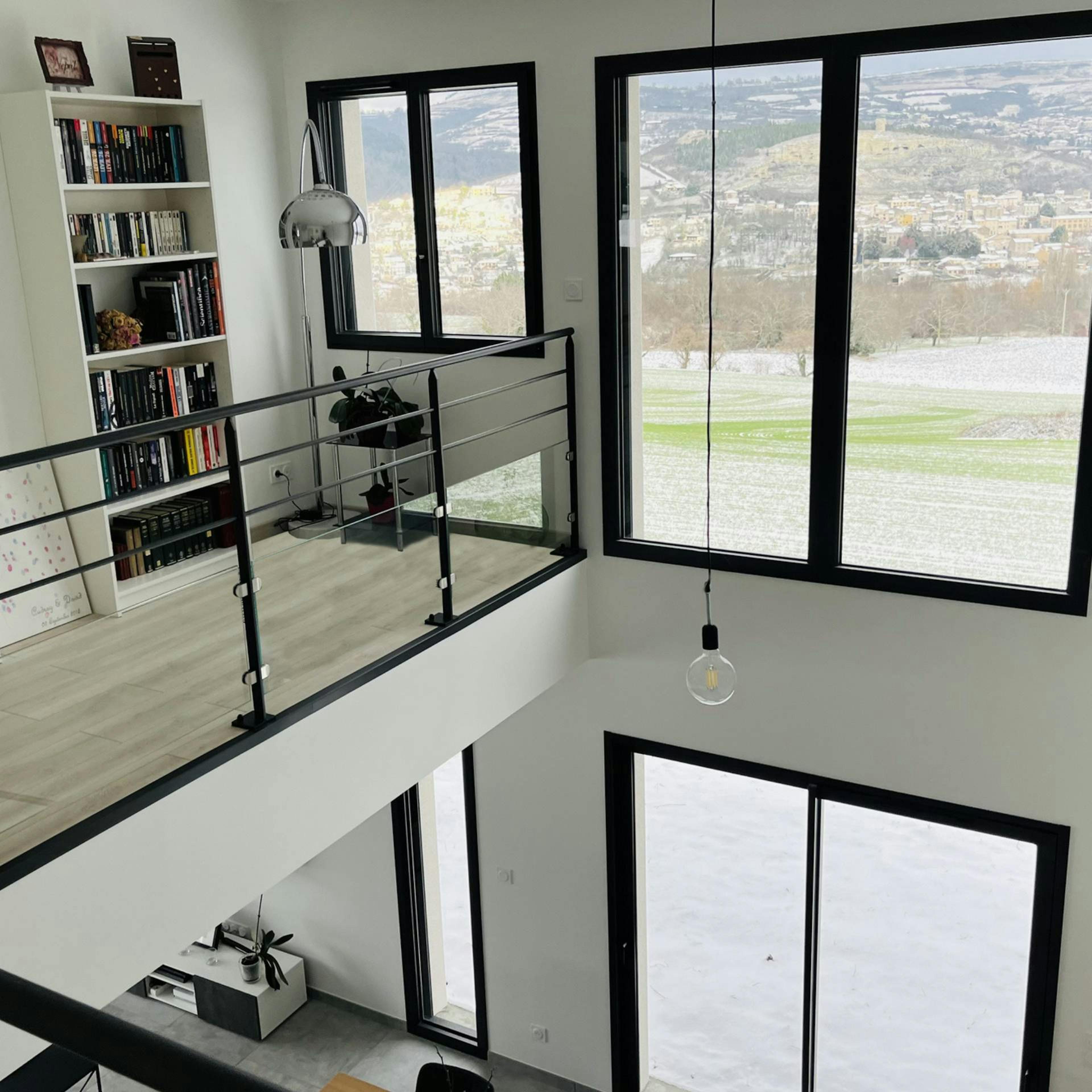 Bibliothèque sur mezzanine avec vue sur les monts d'Auvergne