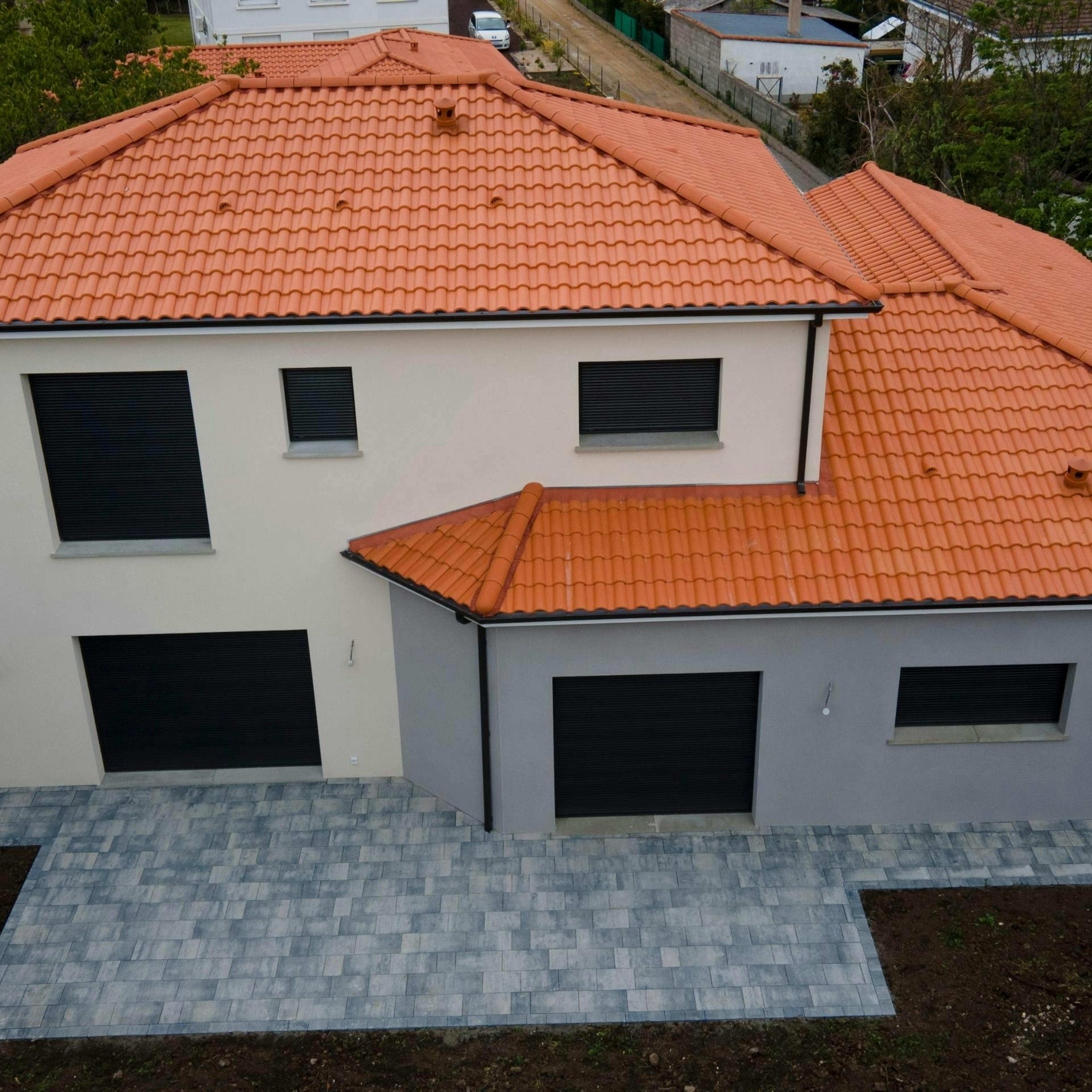 Façades avec décrochés terrasse pavée et menuiserie noir