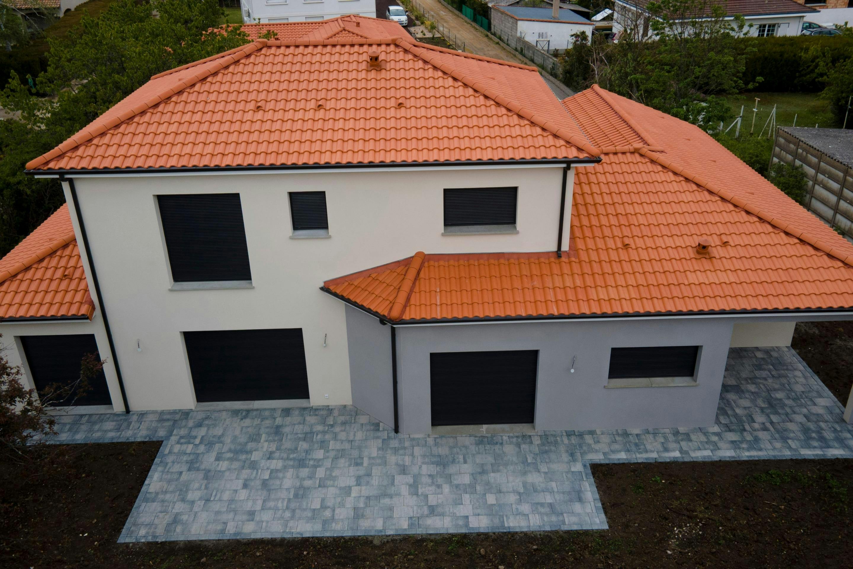 Façades avec décrochés terrasse pavée et menuiserie noir