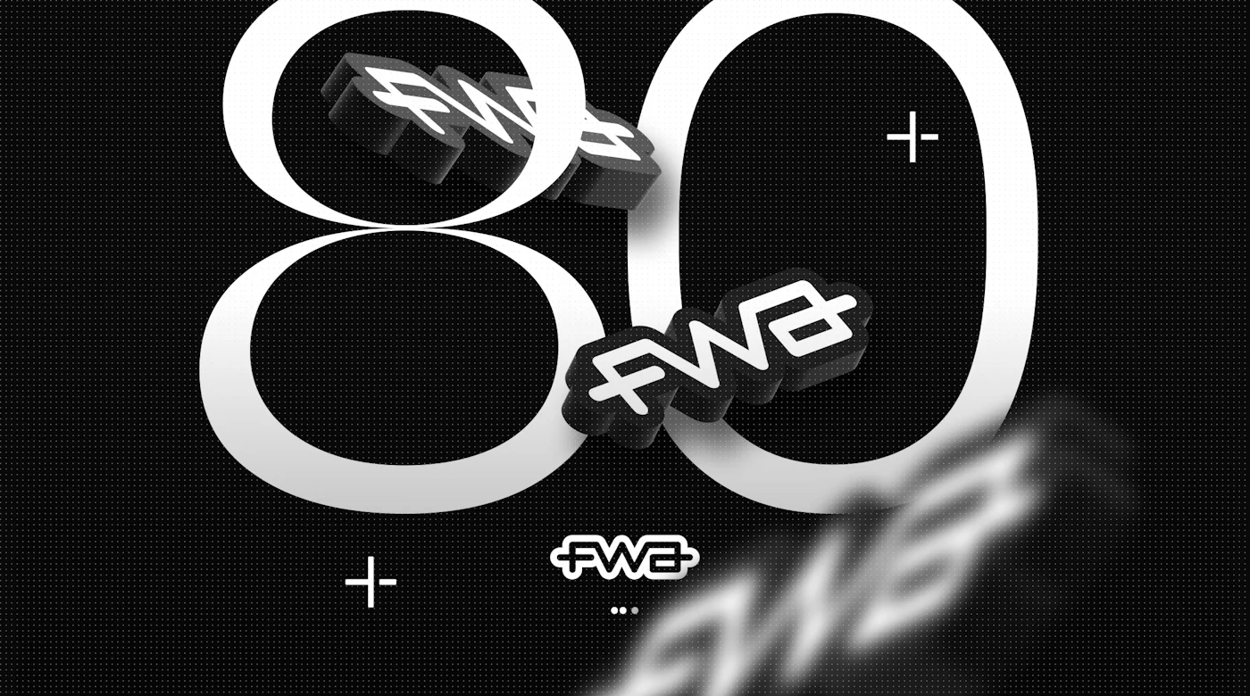 80 awards won, the 3D logo of the FWA is positioned at different depth of field in the image. One is placed behind the top loop of the number 8, the second in front of the 0 and the last one is blurred and at the very foreground.