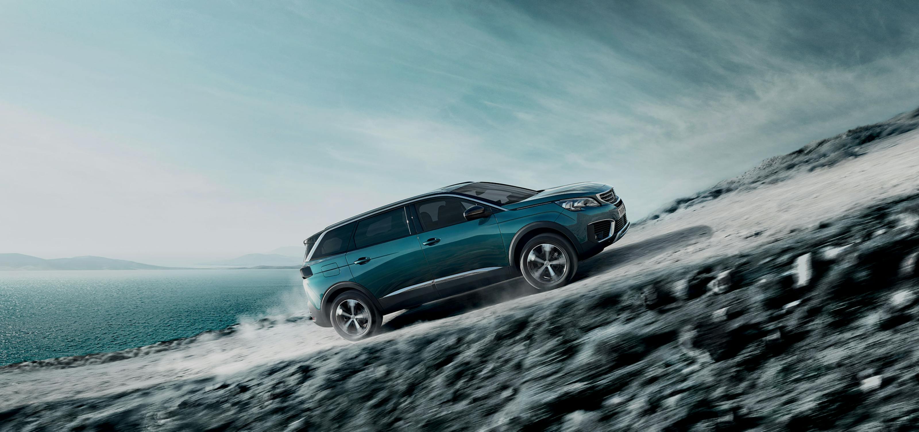 Blue peugeot 3008 driving on a steep slope