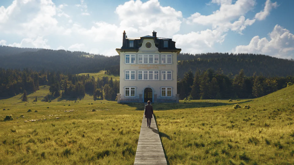 A building standing in a natural landscape, a man is walking toward the building.