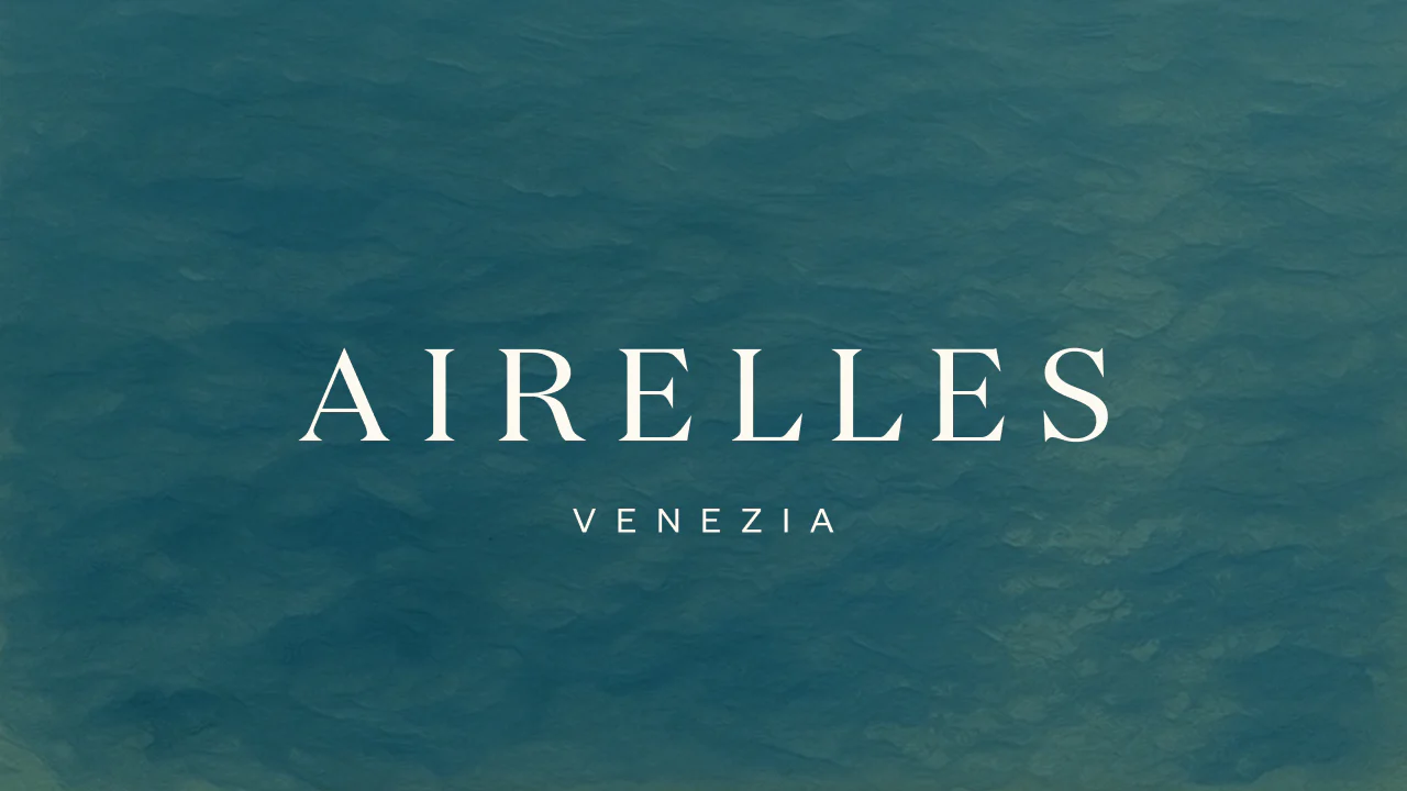 Airelles Venezia logo with blue water in the background.