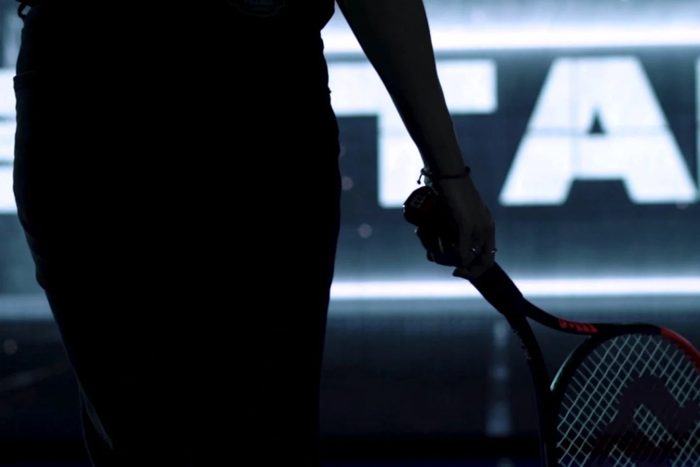 From behind, someone is holding a tennis racket.